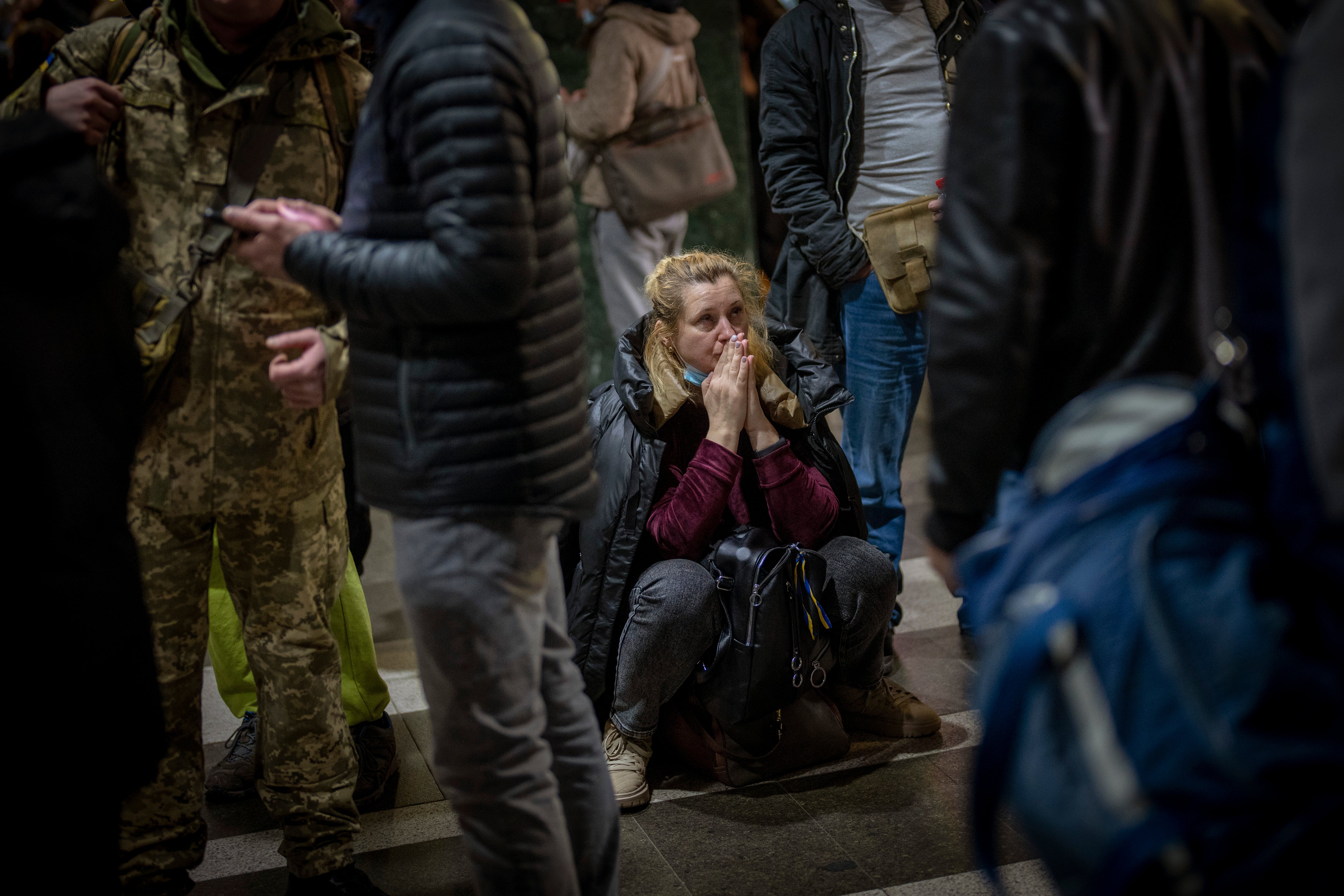 A woman reacts as she waits for a train trying to leave Kyiv, Ukraine, Thursday