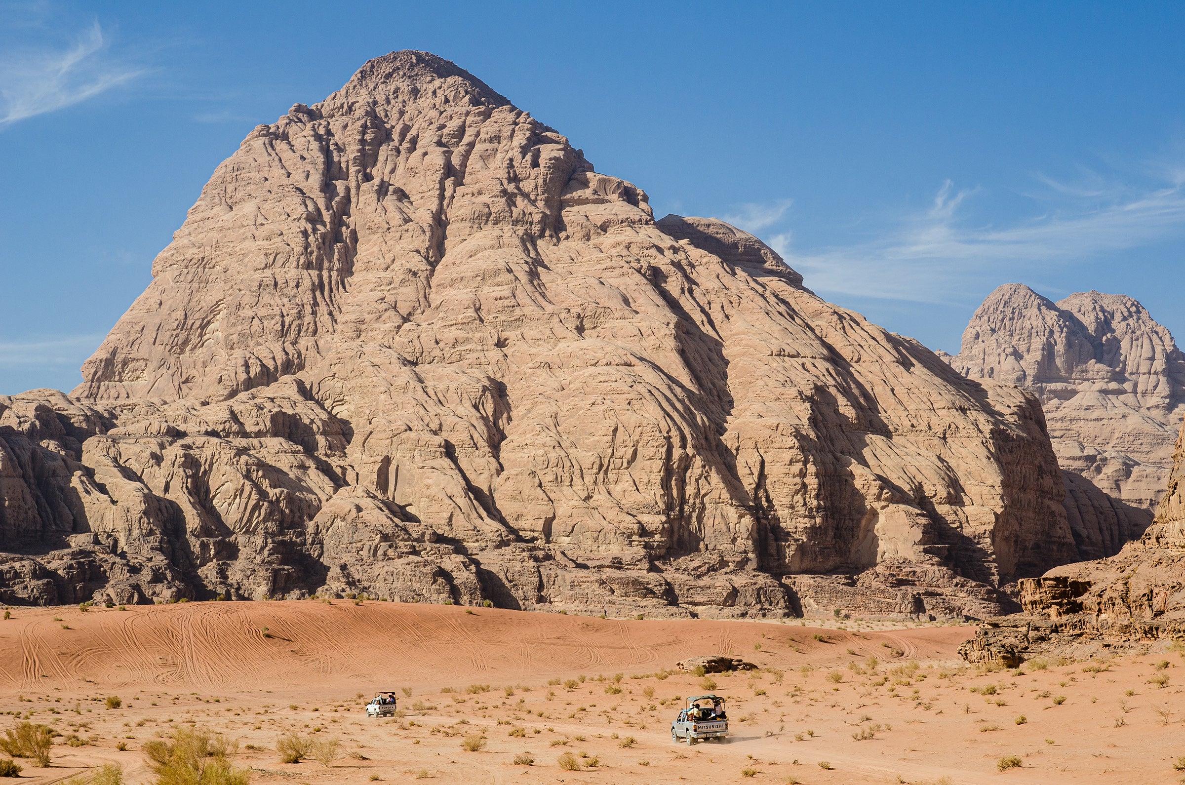 Tourists ride pickup trucks through the desert around Wadi Rum in 2011