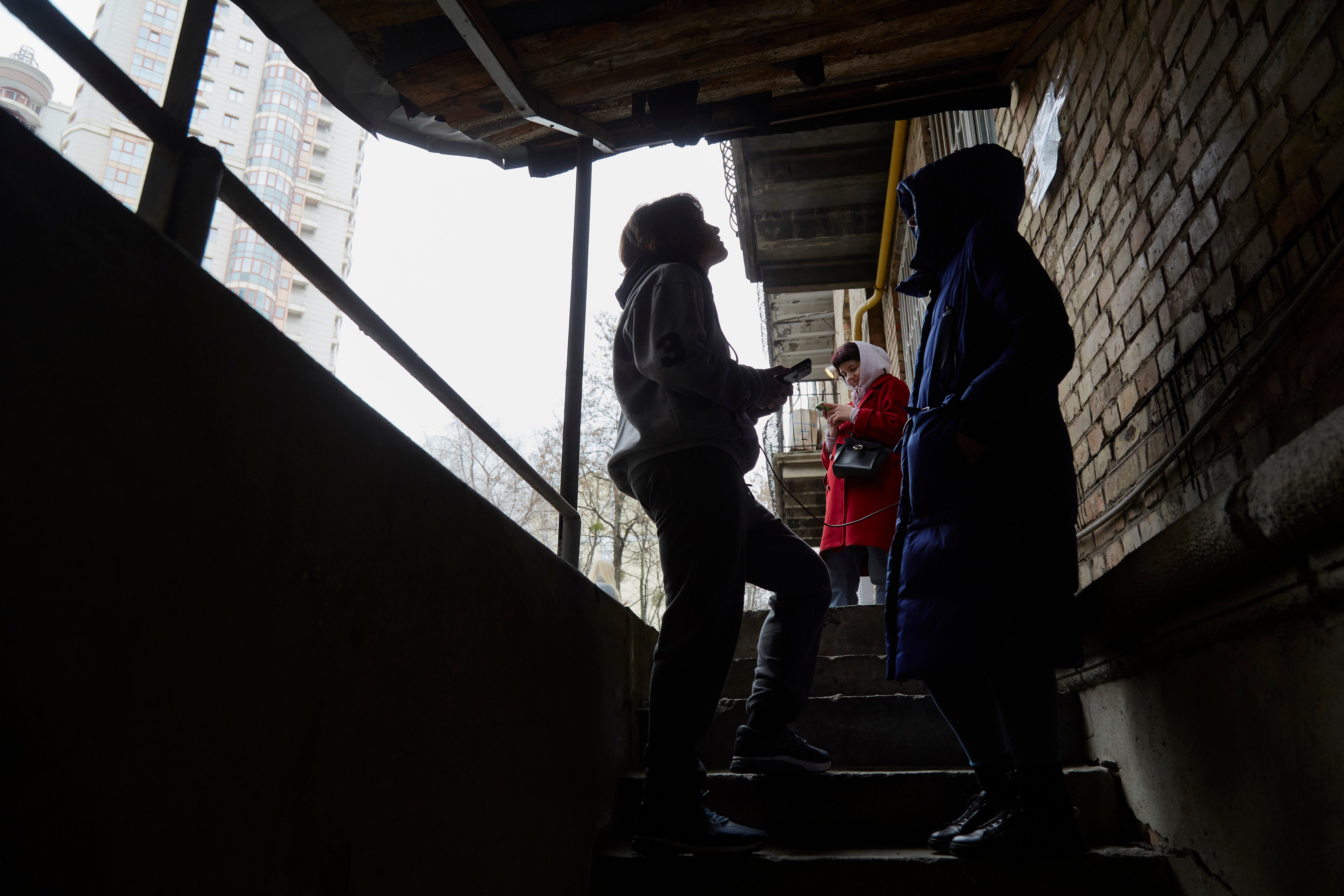 Kyiv residents stand outside bomb shelter in capital on 24 February