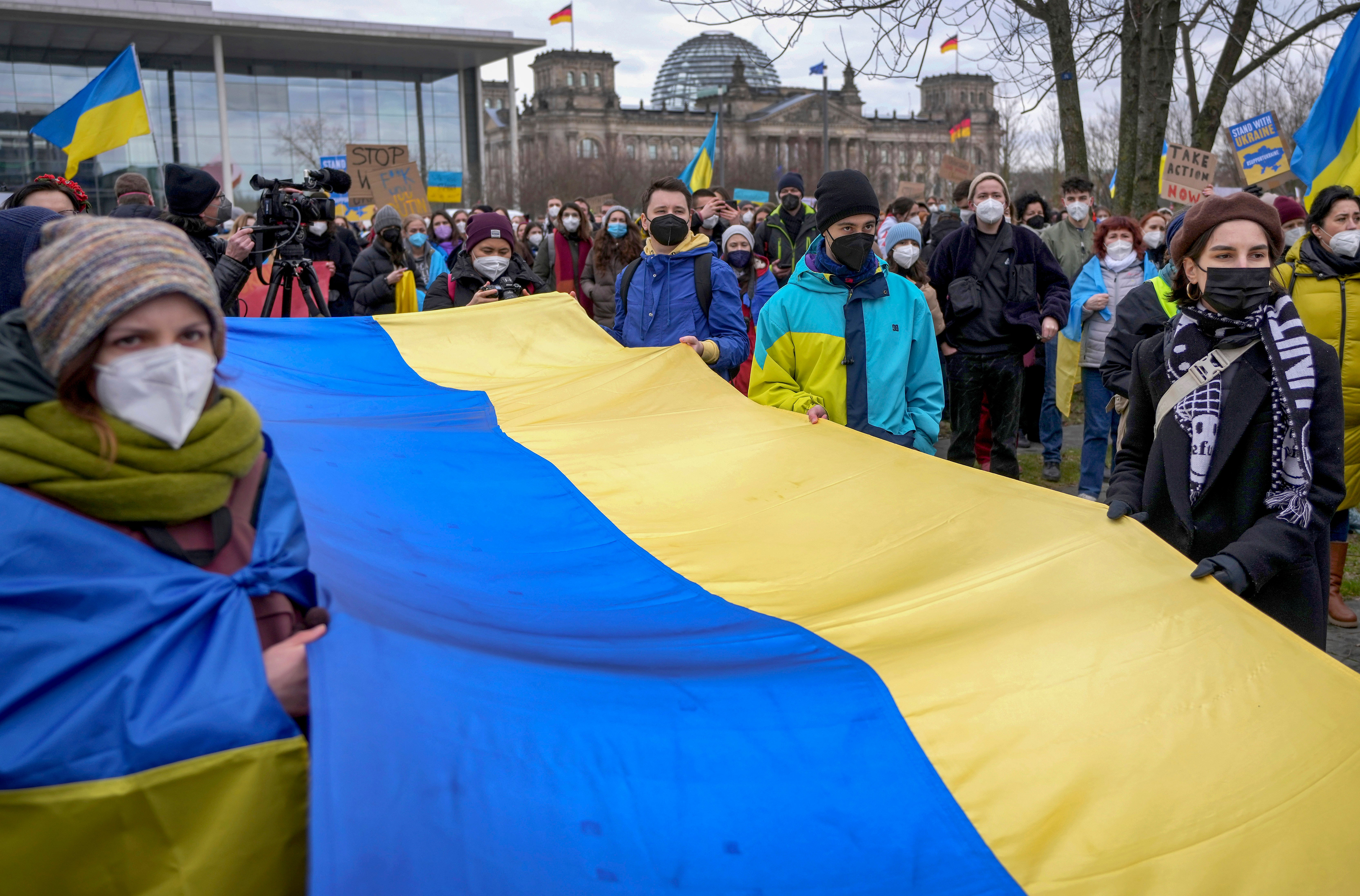 People attend a pro-Ukraine protest rally in front of the Chancellery close to the Reichstag building in Berlin, Germany,