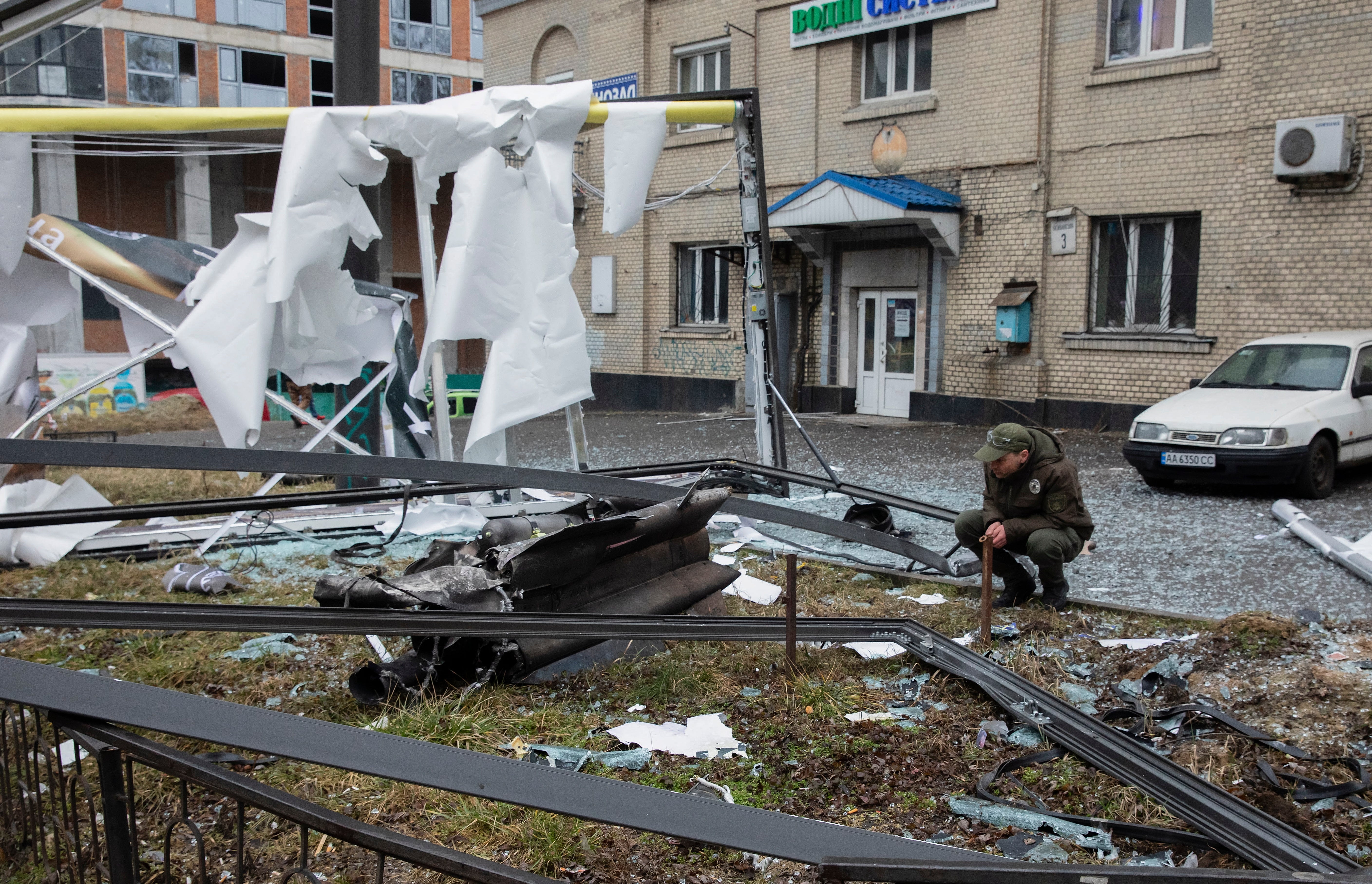 A man looks at the debris of an unidentified object in the aftermath of an explosion in Kiev, Ukraine