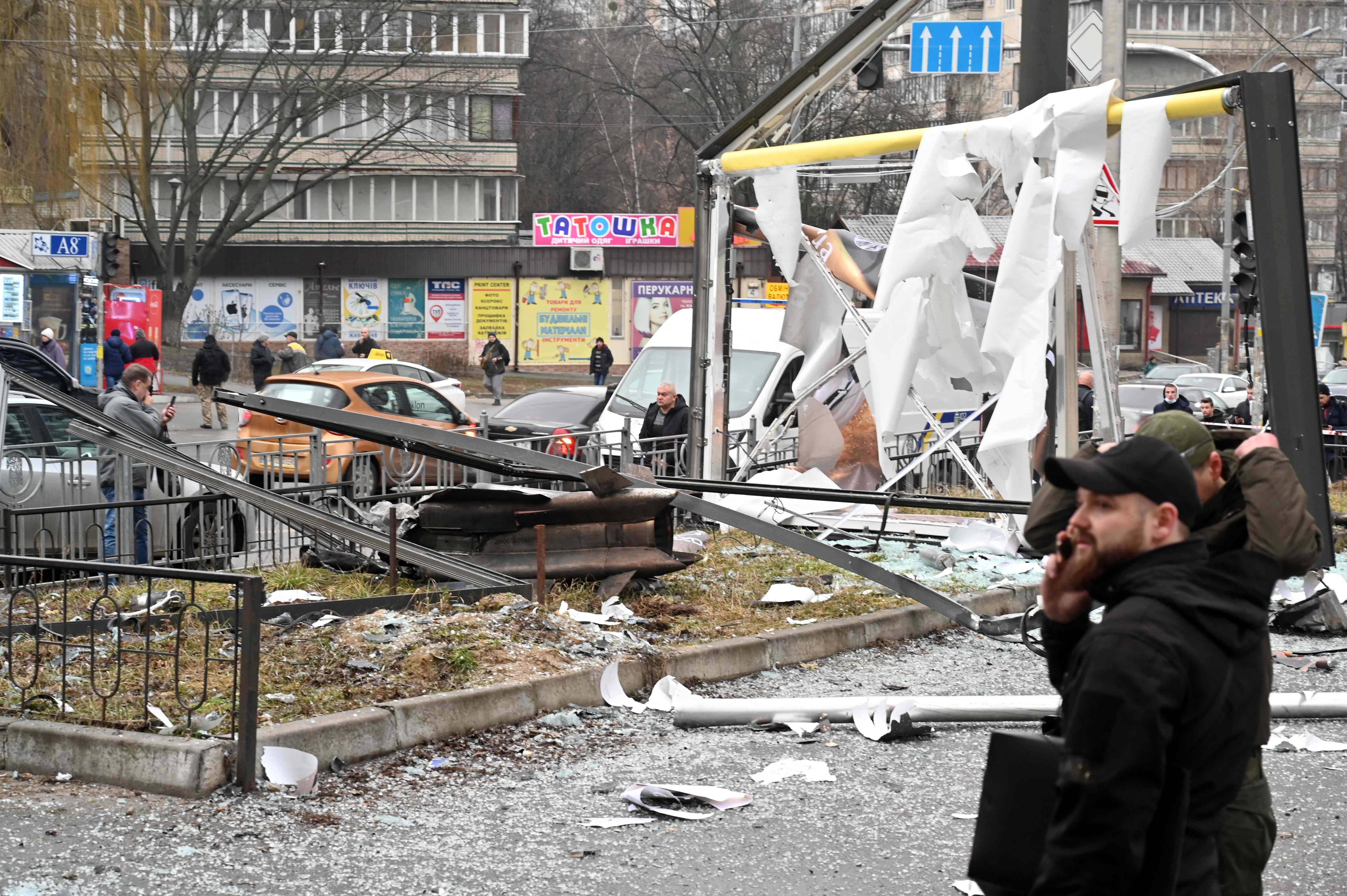 Police and security personnel inspect the remains of a shell landed in Kiev