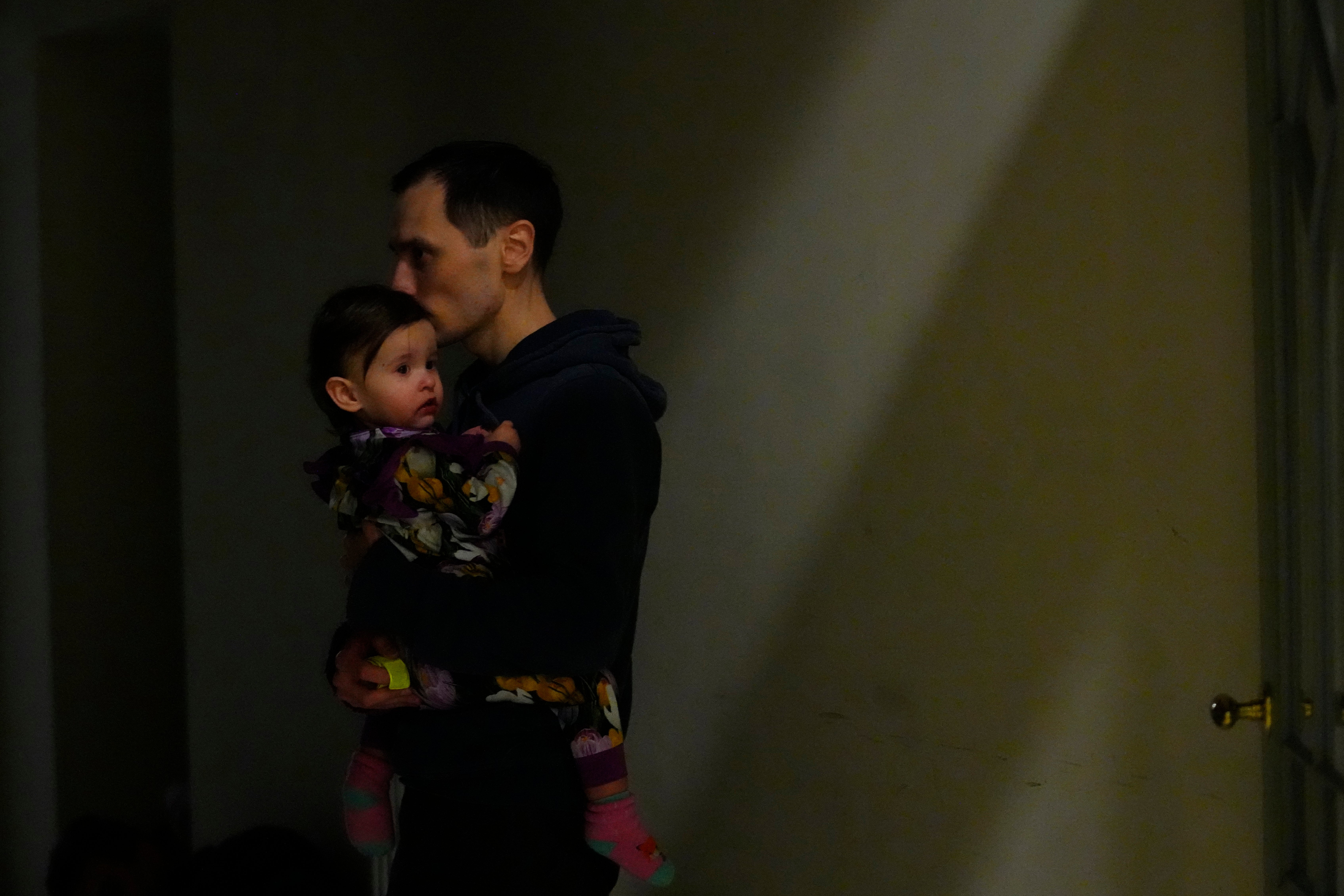 A man from neighboring Ukraine, kisses his daughter at a train station that was turned into an accommodation center in Przemysl, Poland