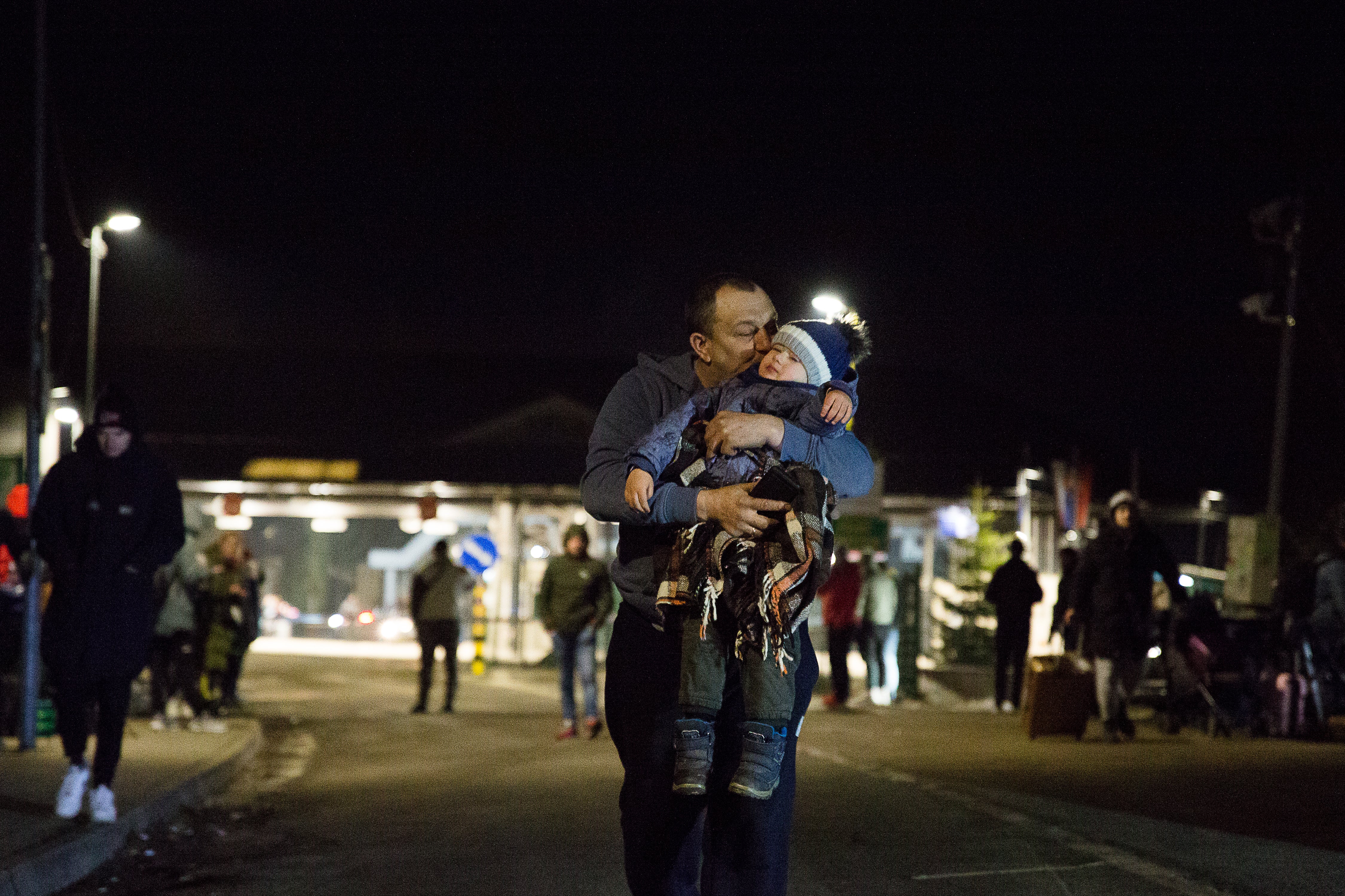 A man kisses a boy who just crossed the border with his relatives on 24 February 2022