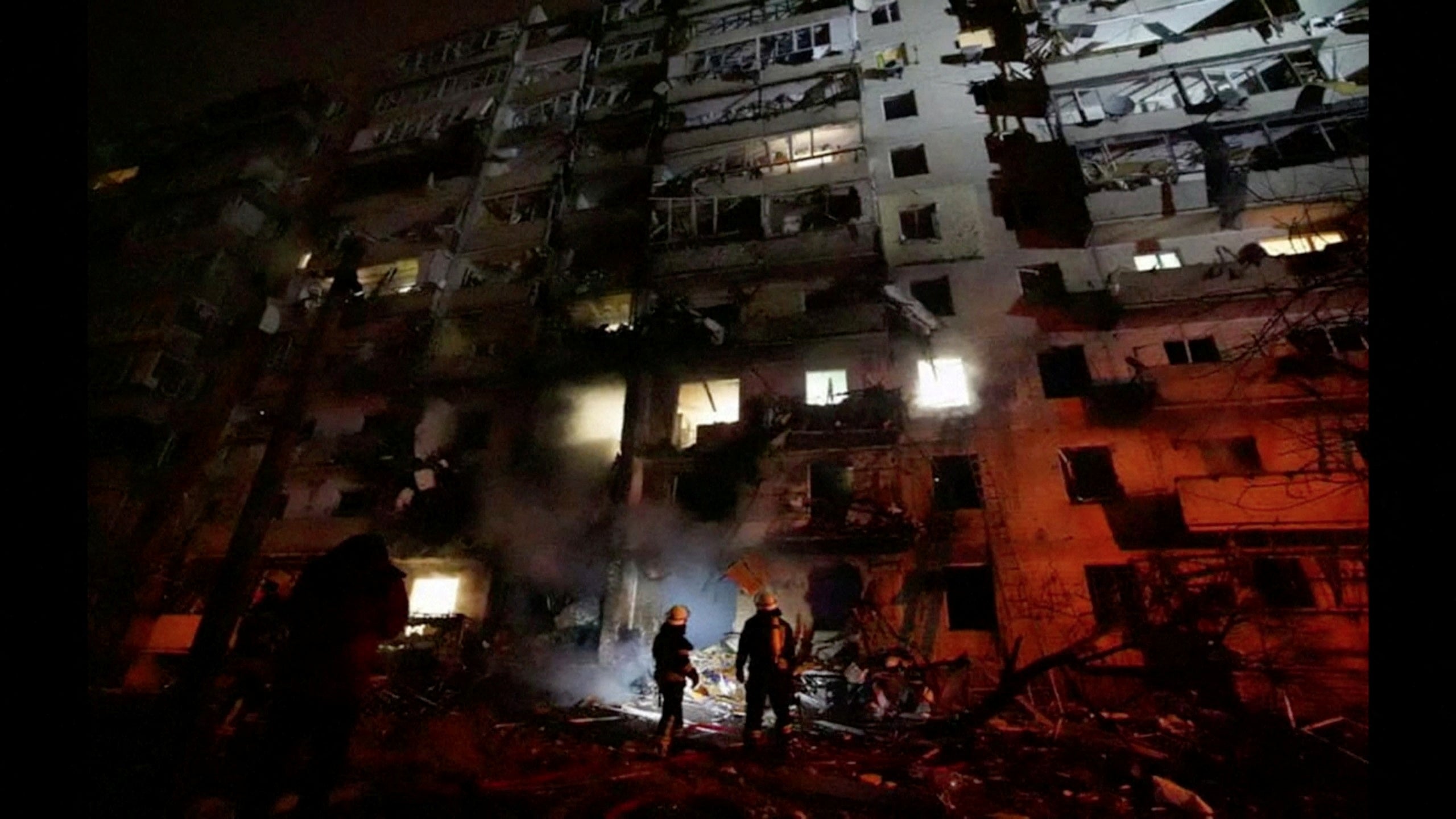 Firefighters work at the site of a damaged residential building, after Russia launched a massive military operation against Ukraine