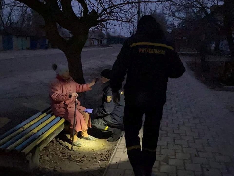 Rescuers help a local resident after shelling in the town of Starobilsk