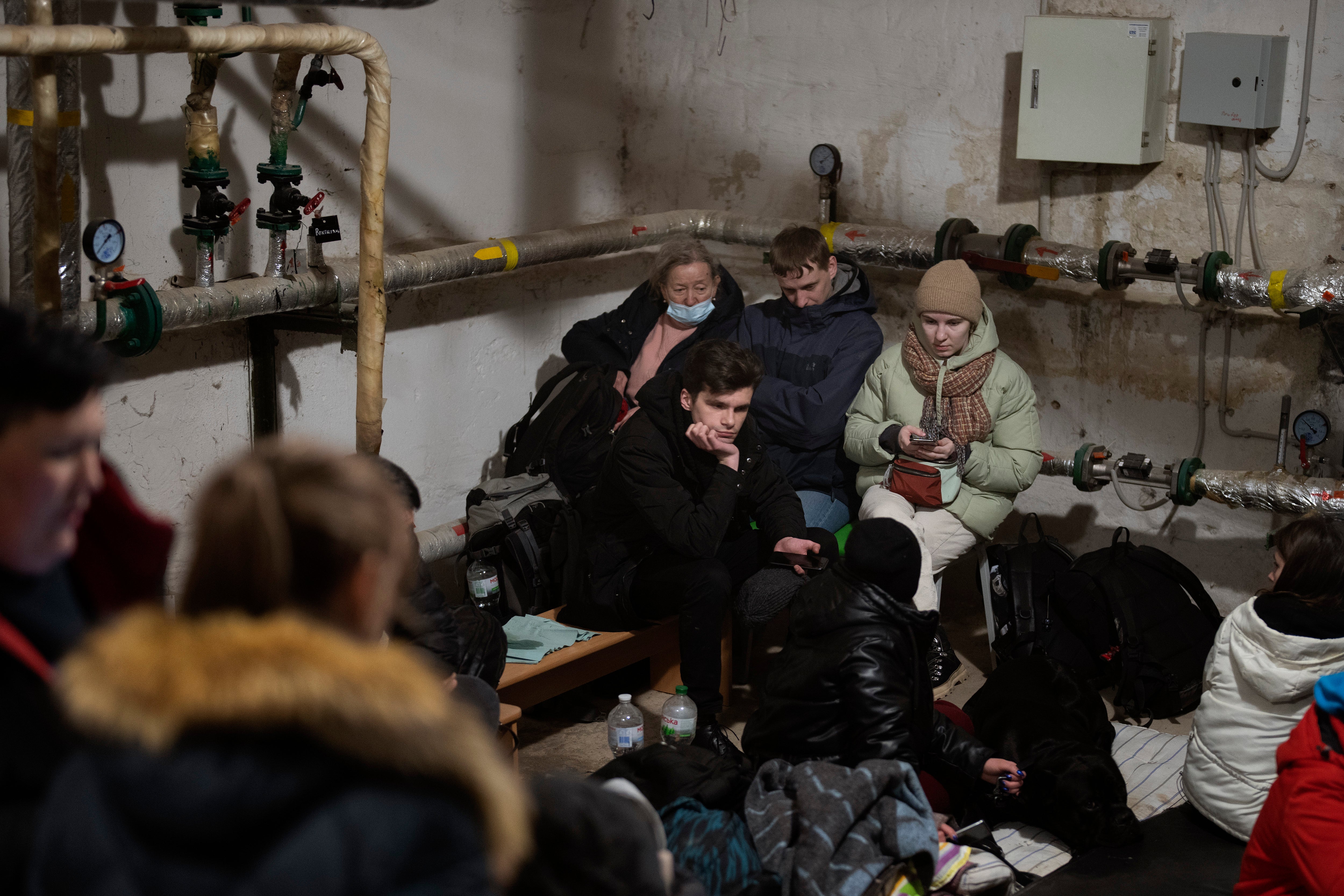 People take shelter at a building basement while the sirens sound announcing new attacks in the city of Kyiv, Ukraine