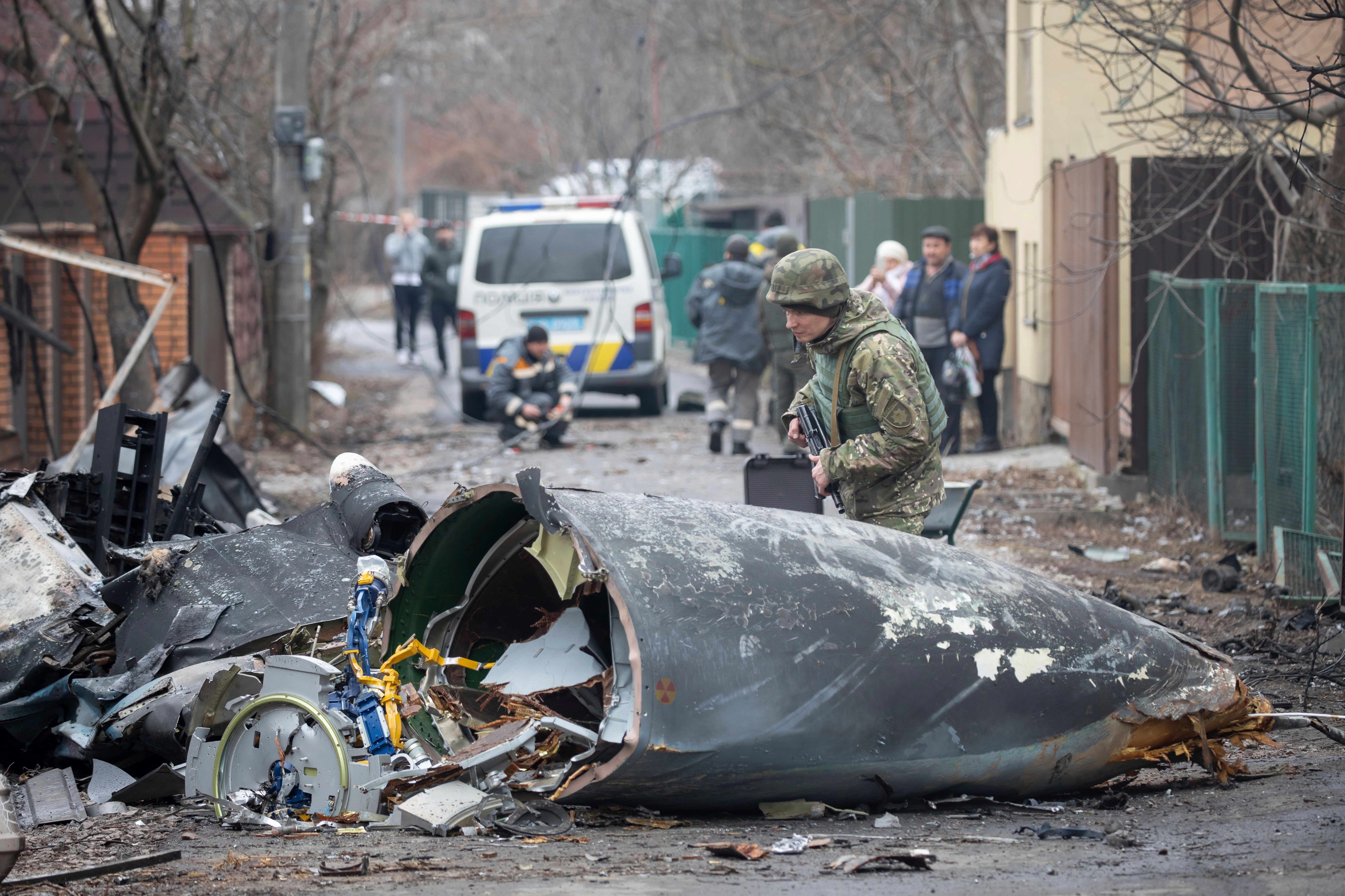 A Ukrainian army soldier inspects fragments of a downed aircraft in Kyiv