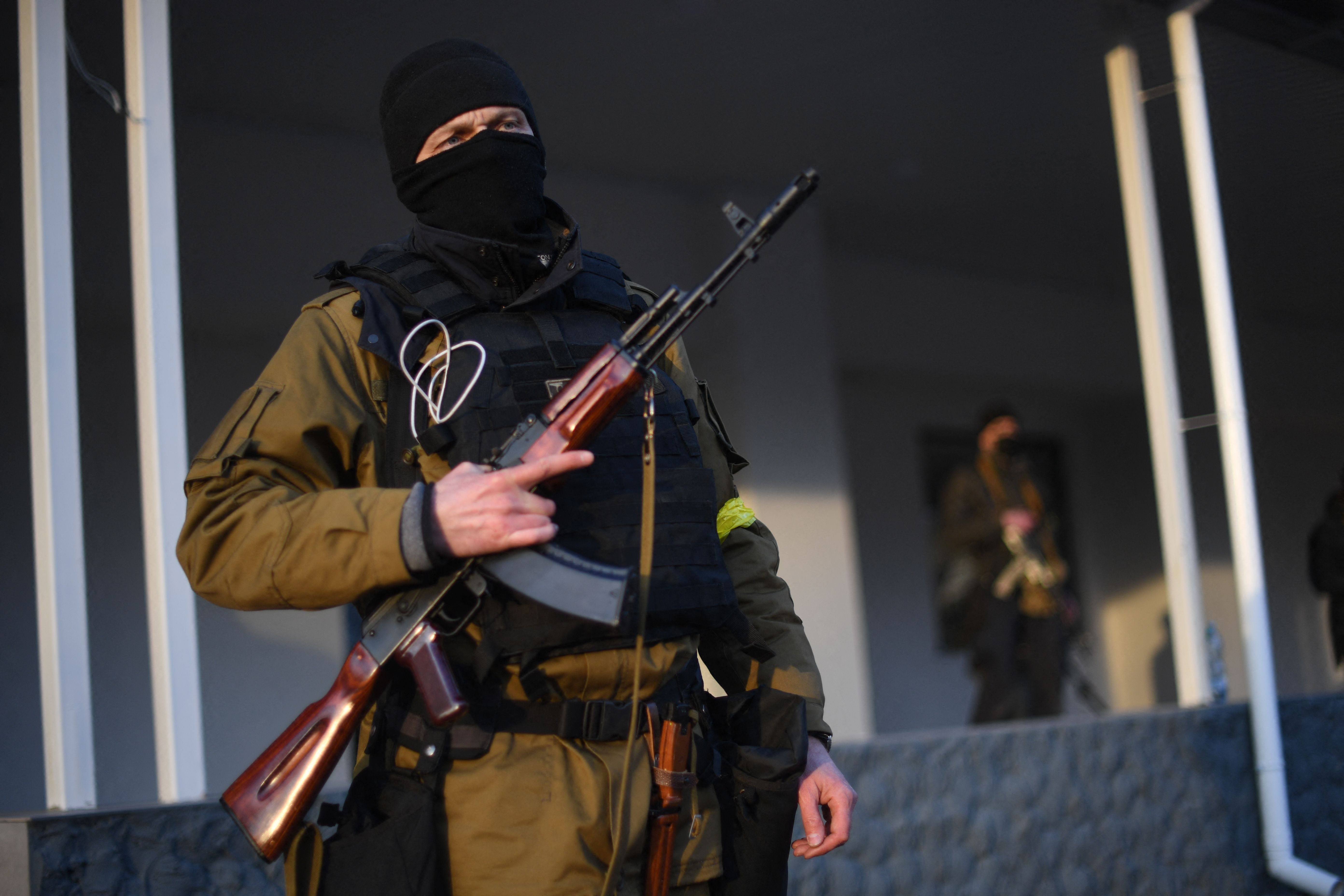 Armed civilian volunteers stand alert on a street in Kyiv