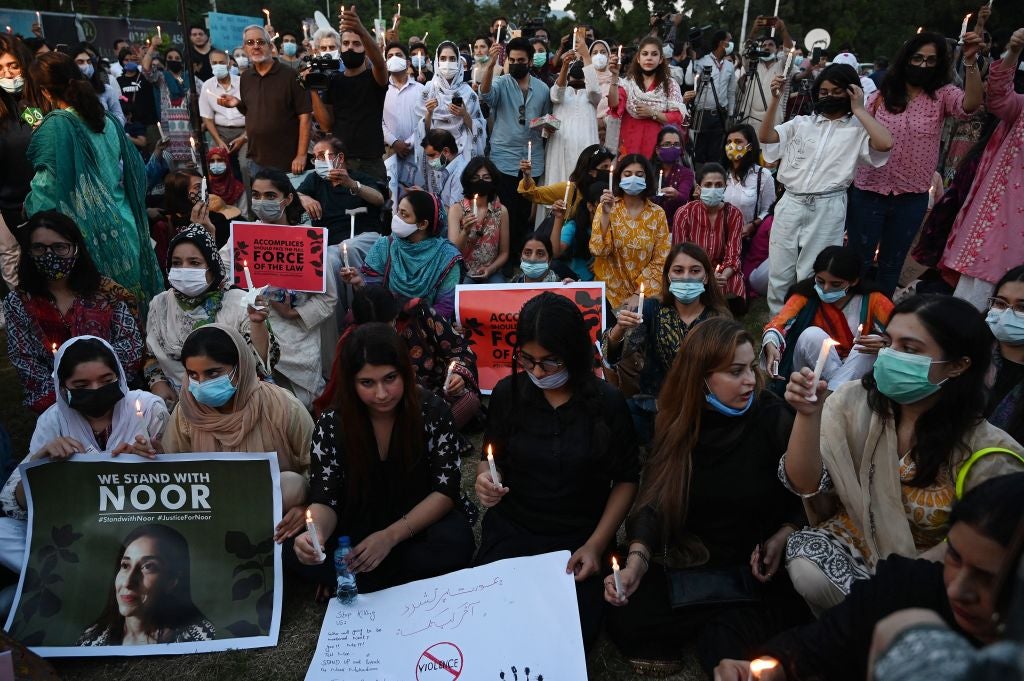 Women rights activists hold placards and candles during a protest rally against the brutal killing of Noor Muqaddam, the daughter of a former Pakistani diplomat who was found murdered at a house in Pakistan's capital