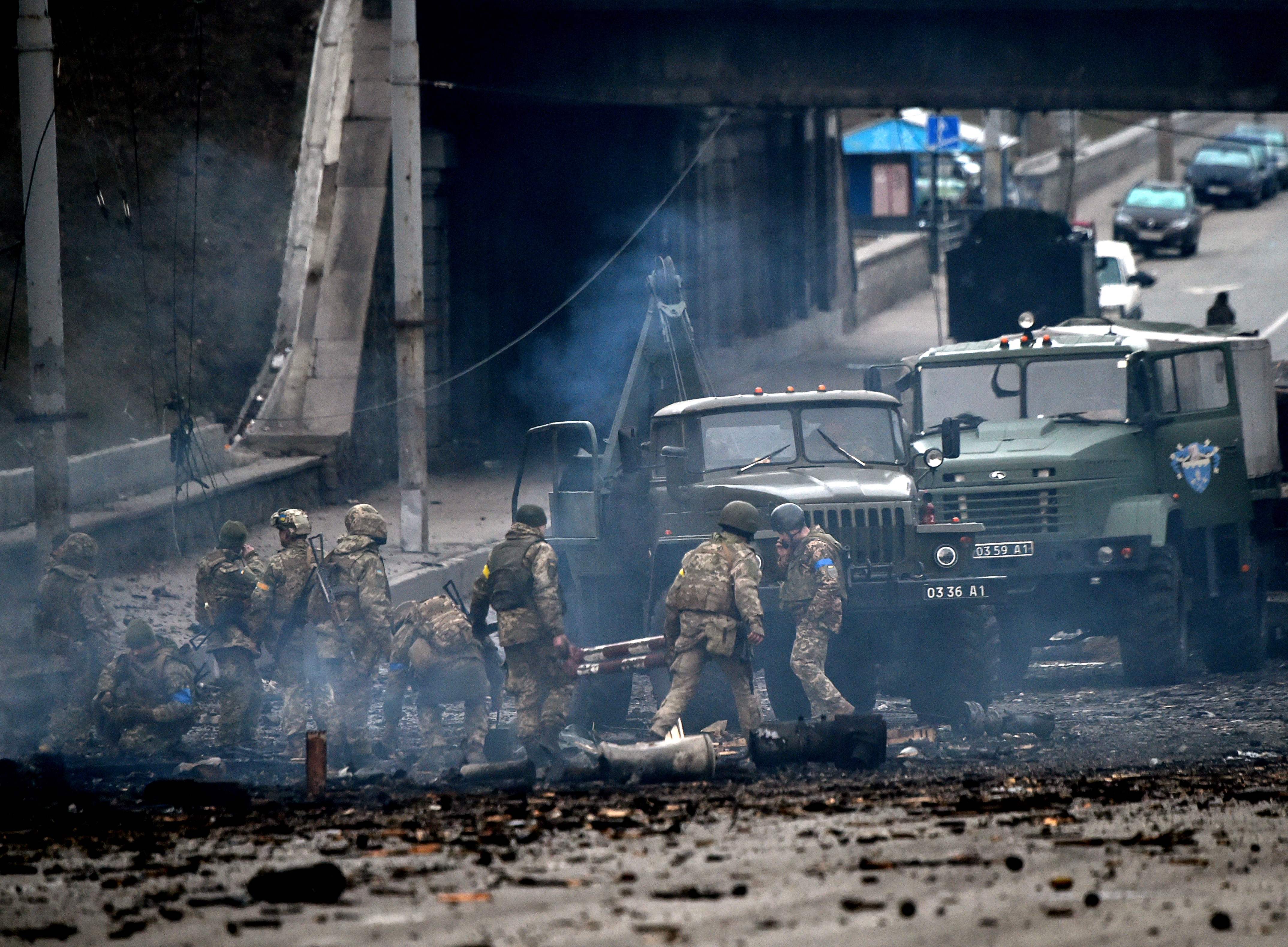 Ukrainian service members collect unexploded shells in Kyiv