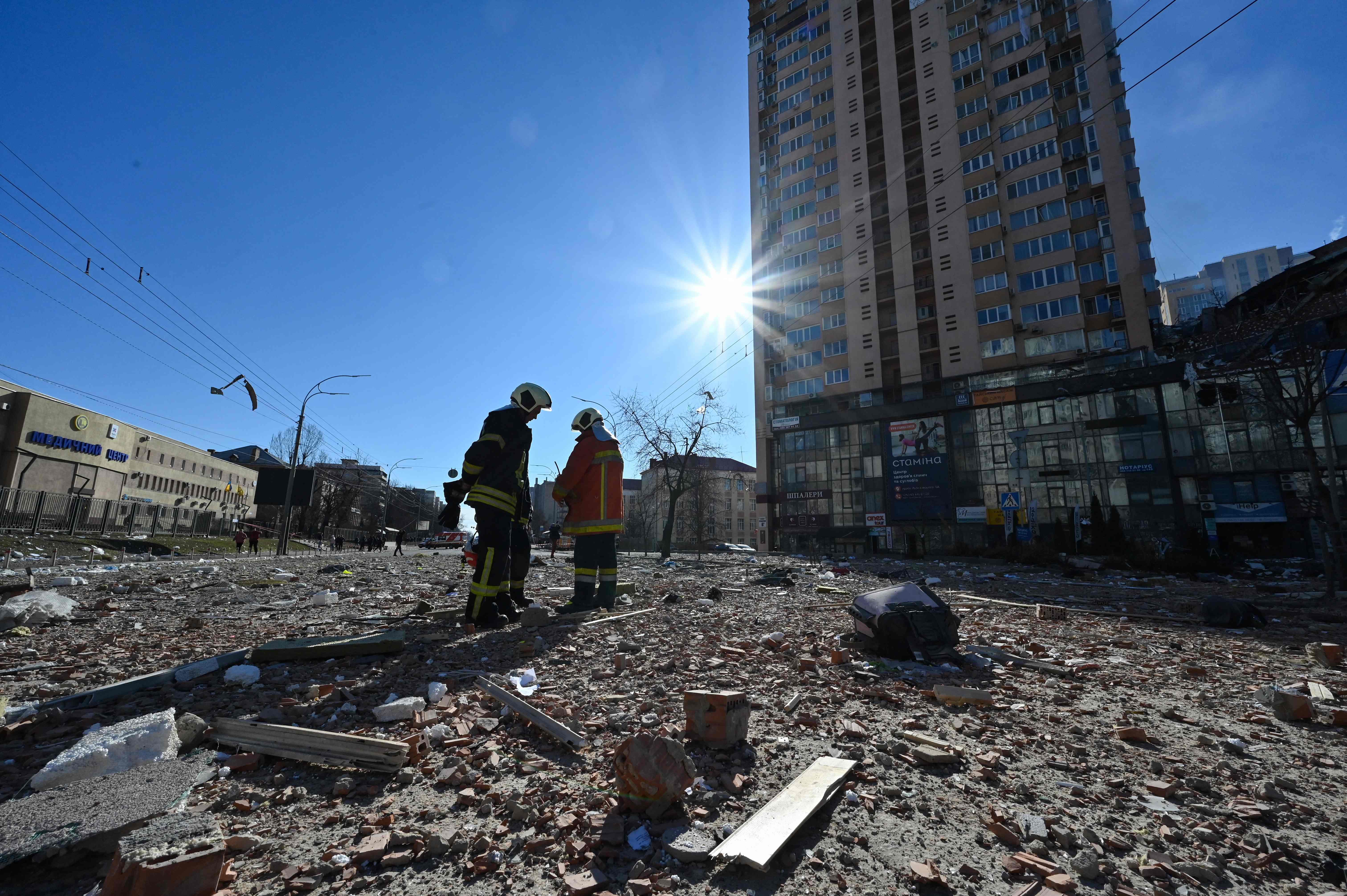 Firefighters work by a high-rise apartment block which was hit by recent shelling in Kyiv on 26 February 2022