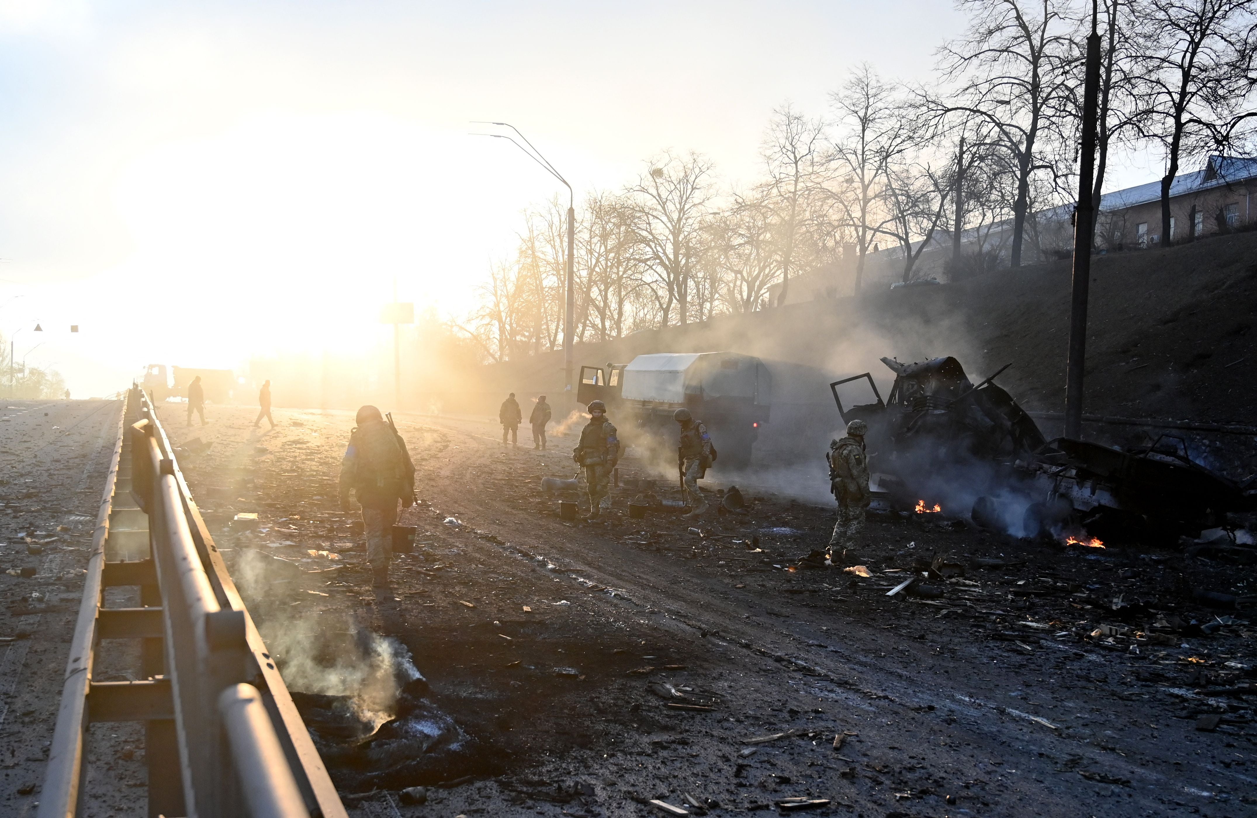 Ukrainian service members look for and collect unexploded shells after a fighting with Russian raiding group in the Ukrainian capital of Kyiv on 26 February 2022