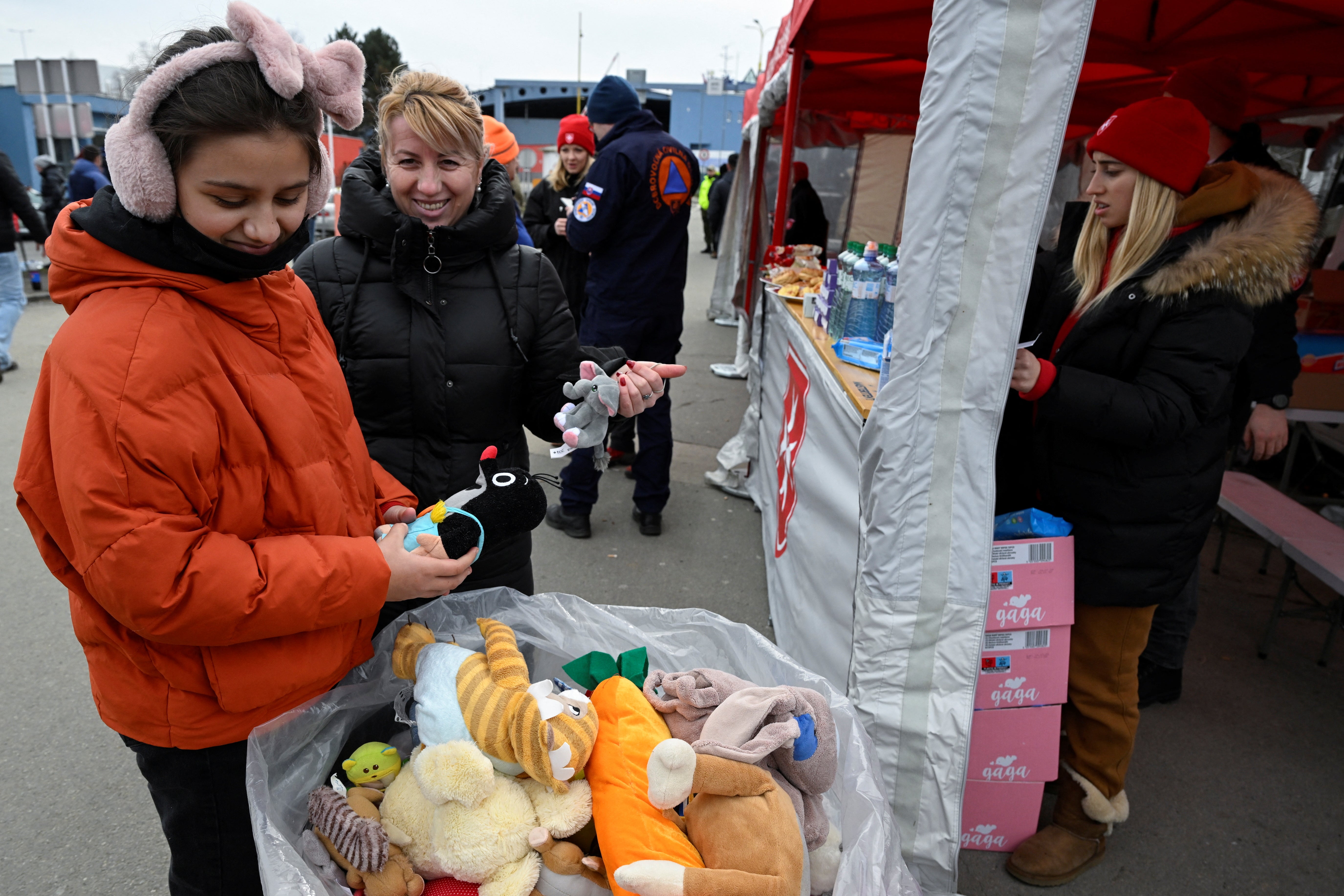 People approach bags of toys for children fleeing from Ukraine who arrive in Slovakia on 26 February 2022