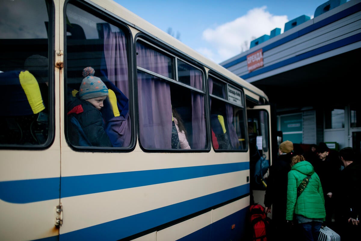 People board a bus as they flee the fighting in Kyiv