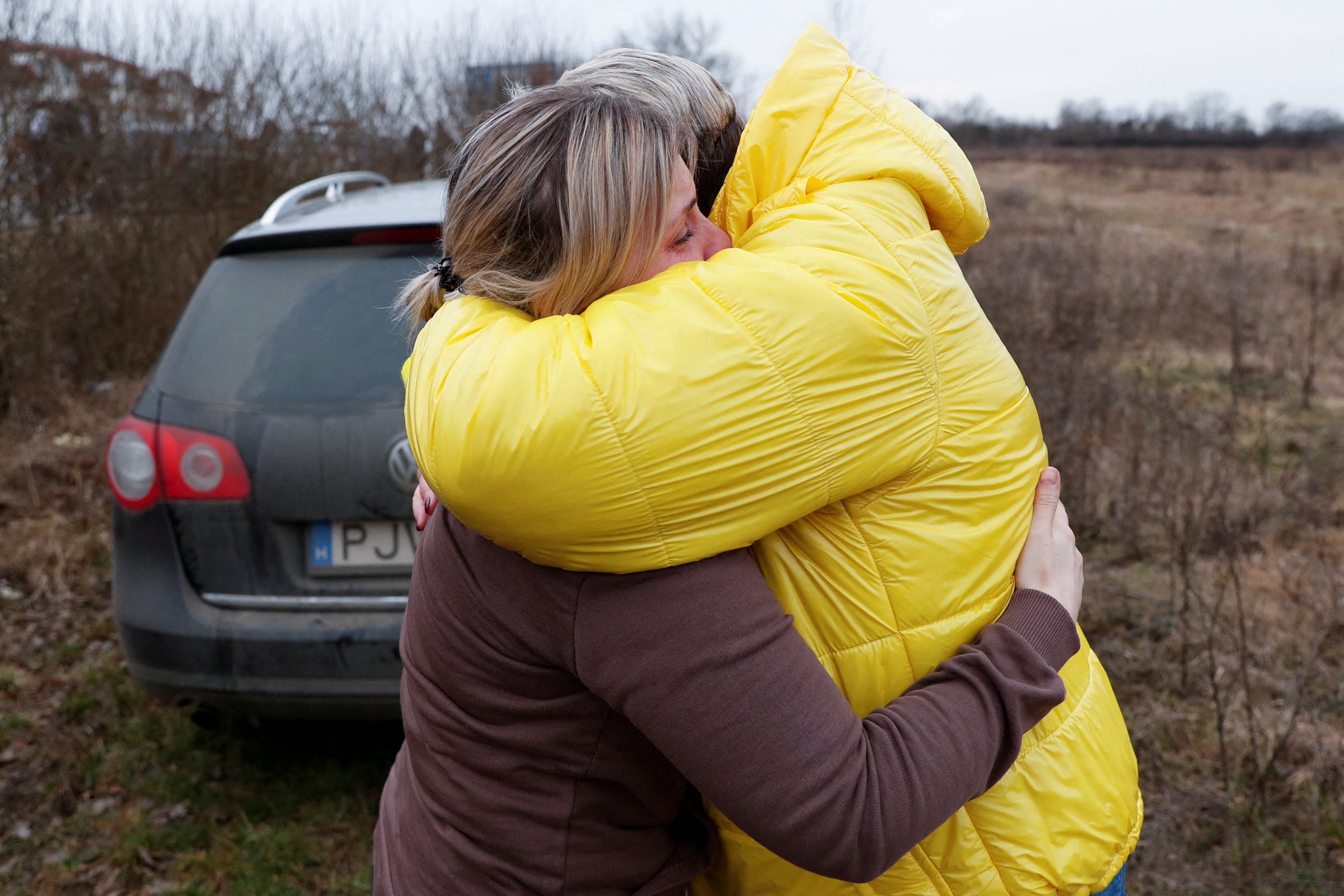 Anna Semyuk, 33, hugs Nataliya Ableyeva, 58, who took her children across the border