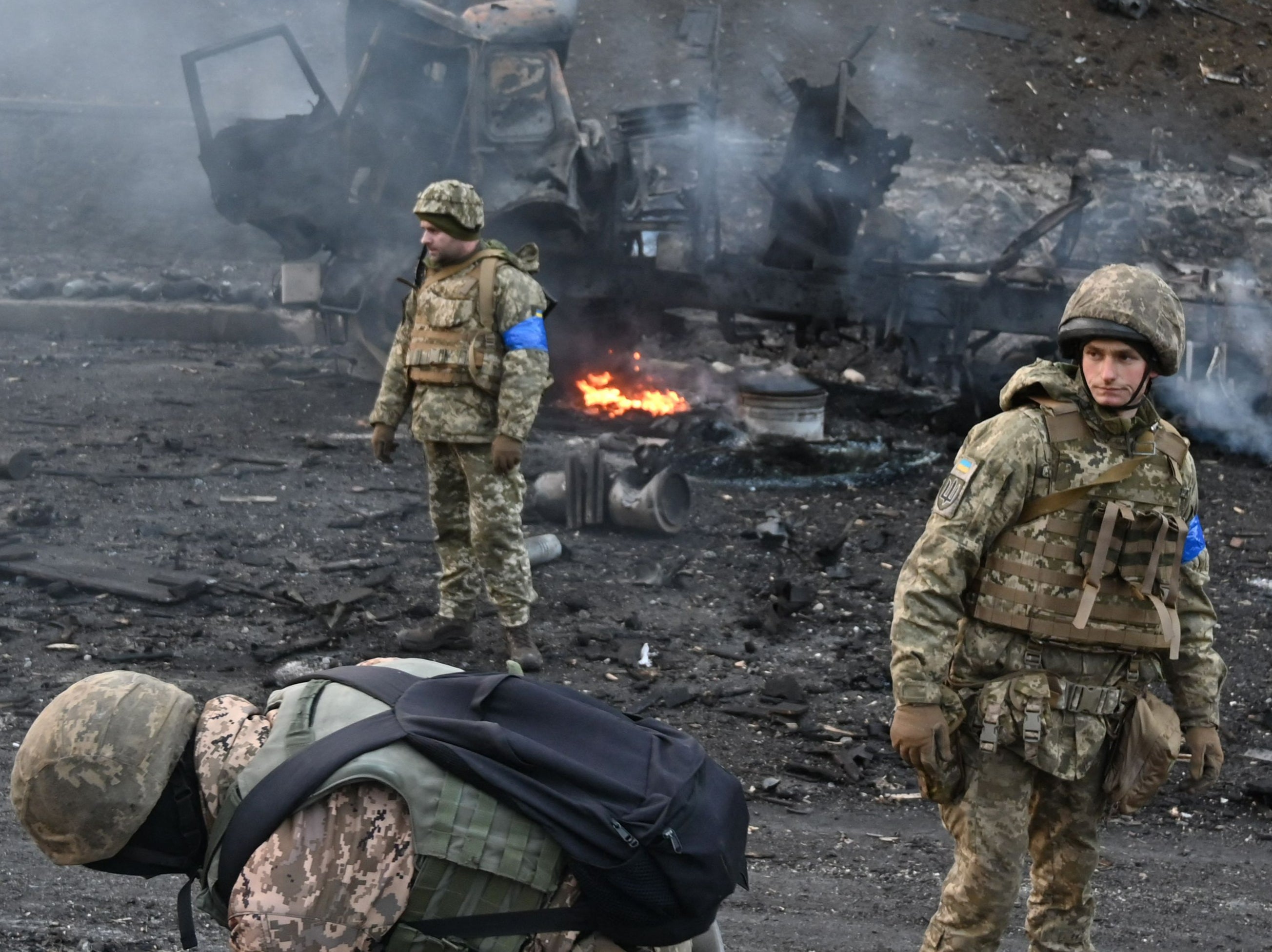 Ukrainian soldiers look for and collect unexploded shells after fighting with Russian troops in Kyiv on Saturday