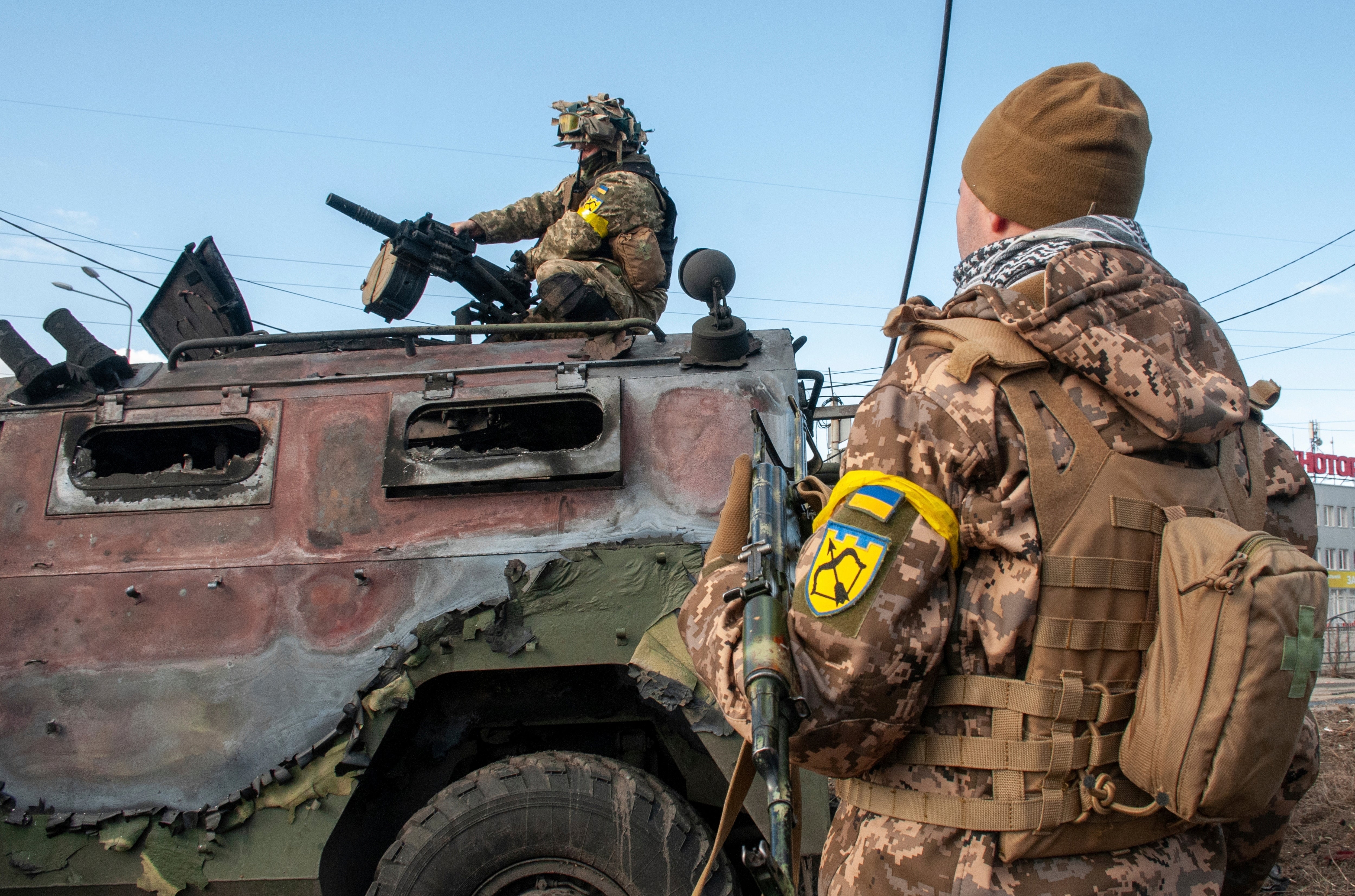 Ukrainian soldiers inspect a damaged military vehicle after fighting in Kharkiv, Ukraine, Sunday, Feb. 27, 2022.