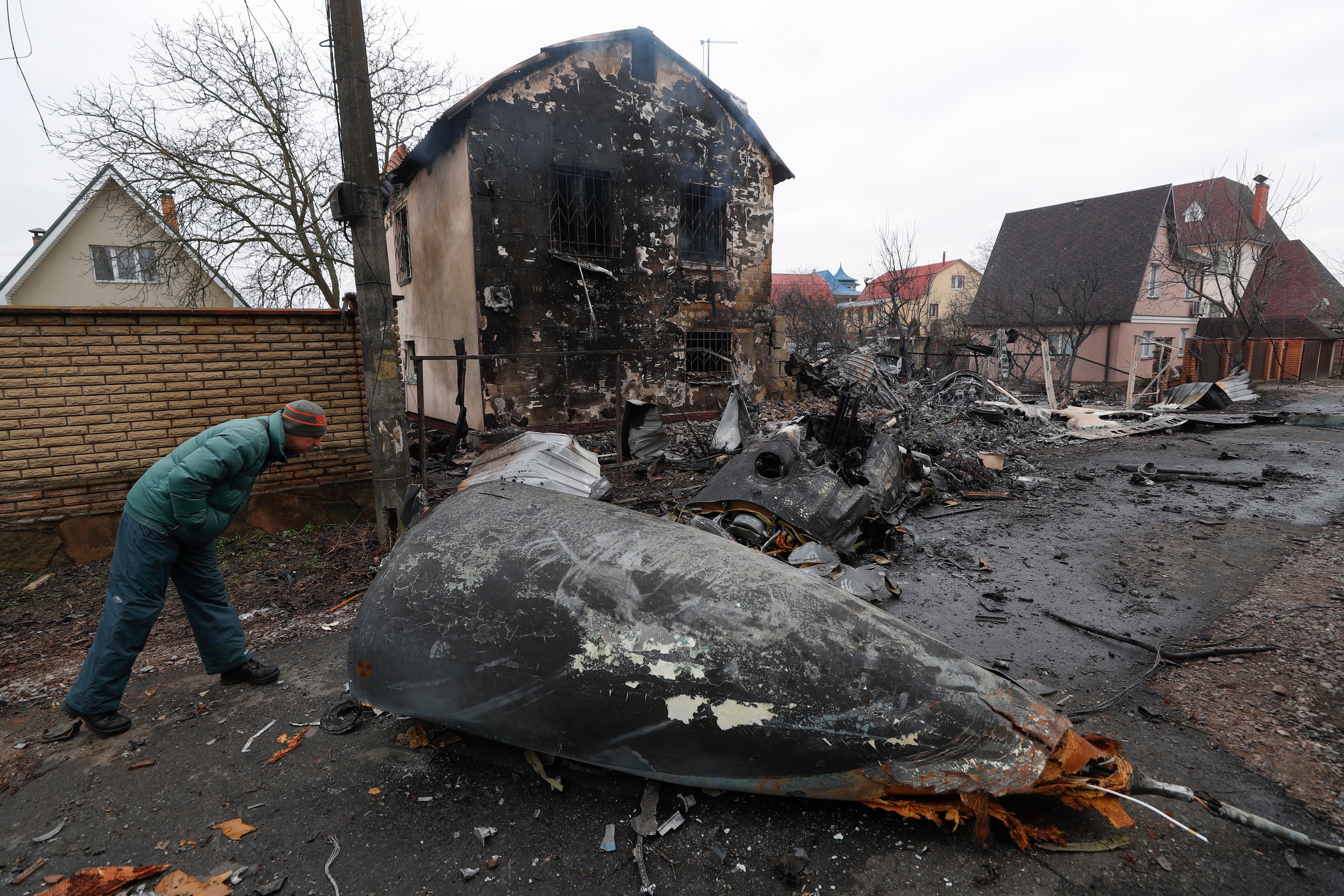 A man looks at the debris of a military plane that was shot down overnight in Kyiv