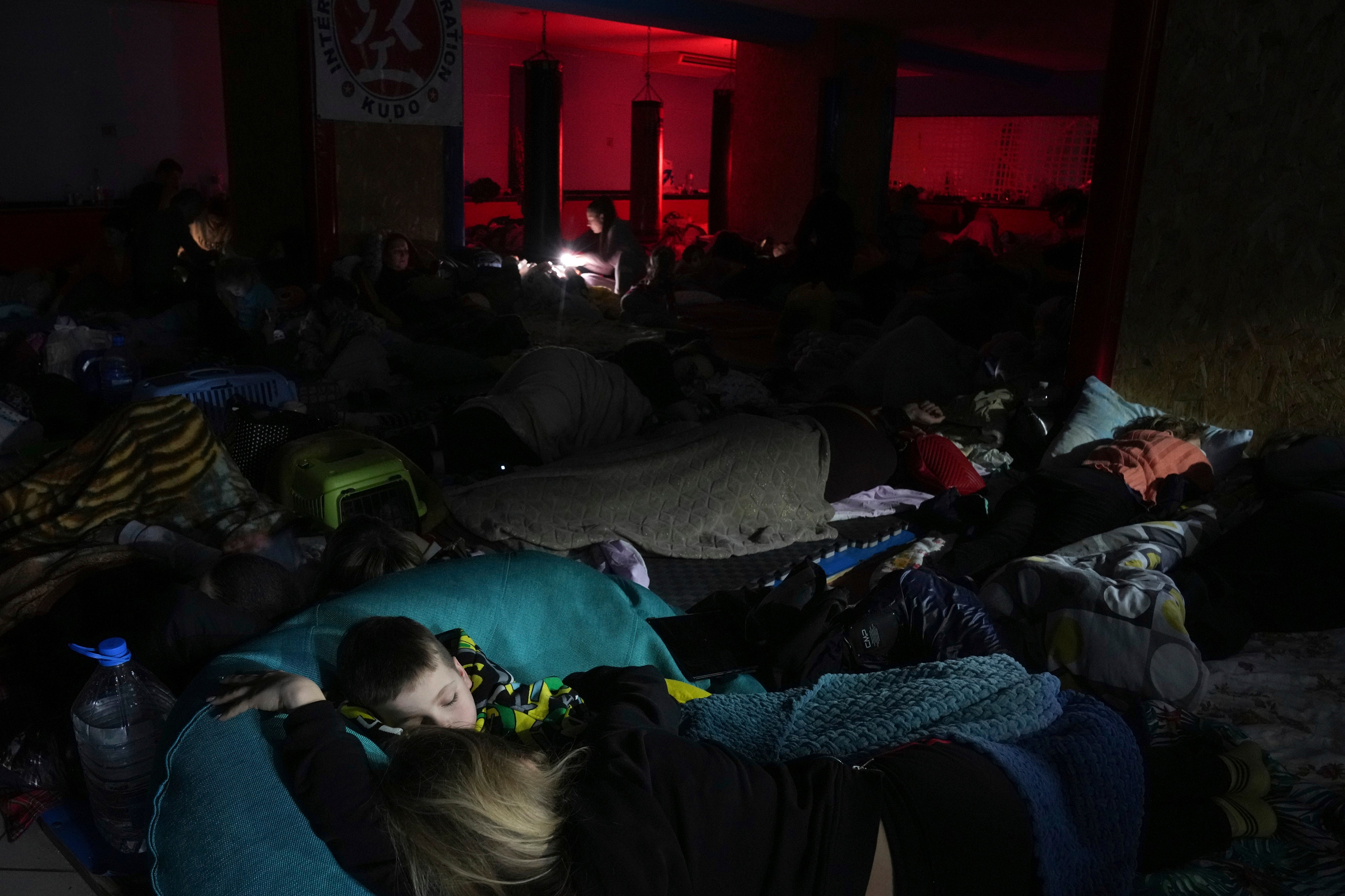 People sleep in the improvised bomb shelter in a sports centre