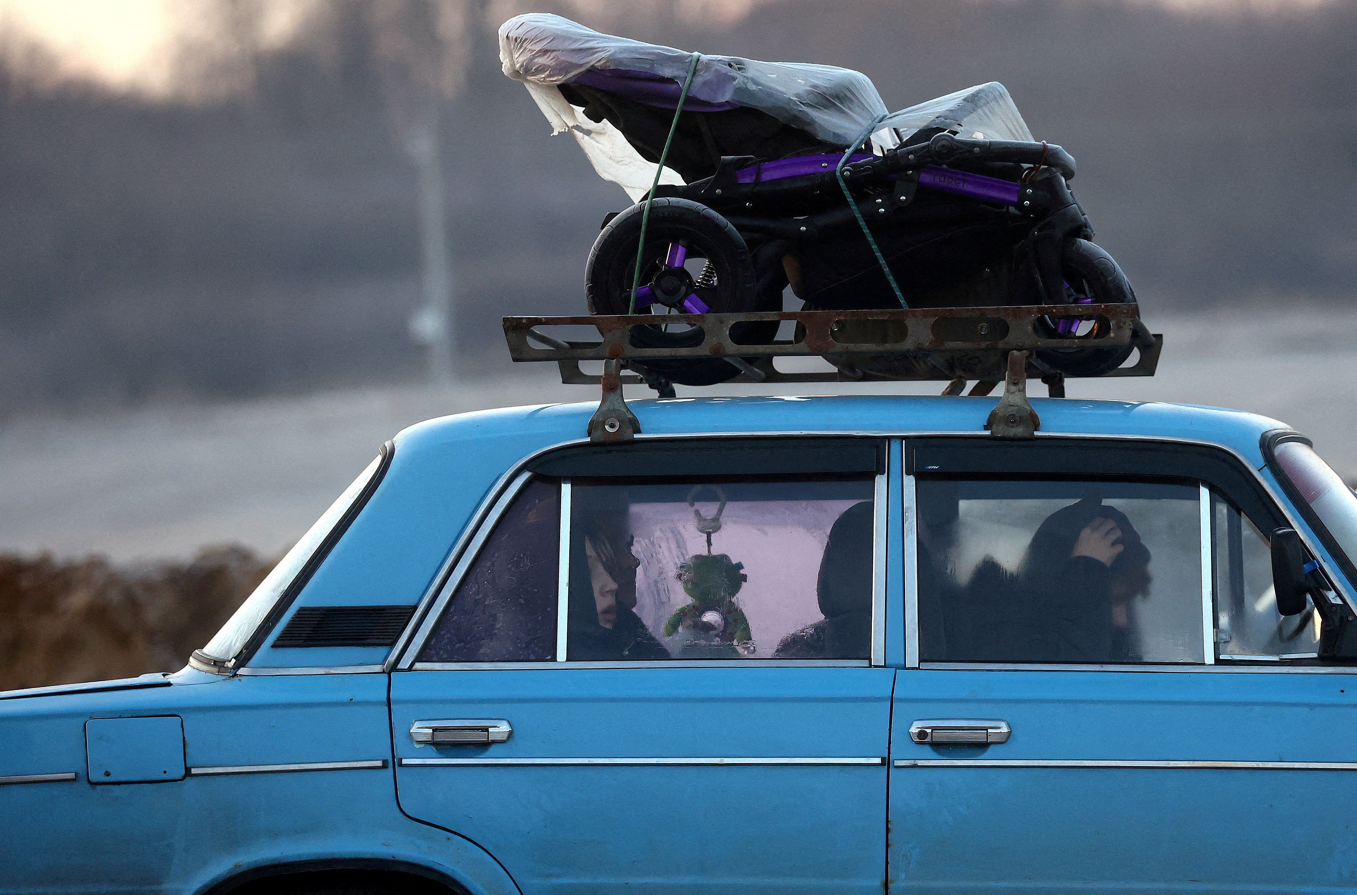 People arrive in an old Lada car after they fled from Ukraine because of the Russian