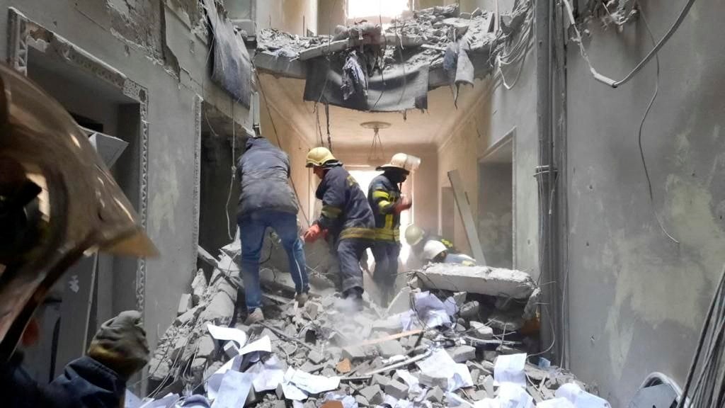 Rescuers are seen in a building, which city officials said was damaged by a missile