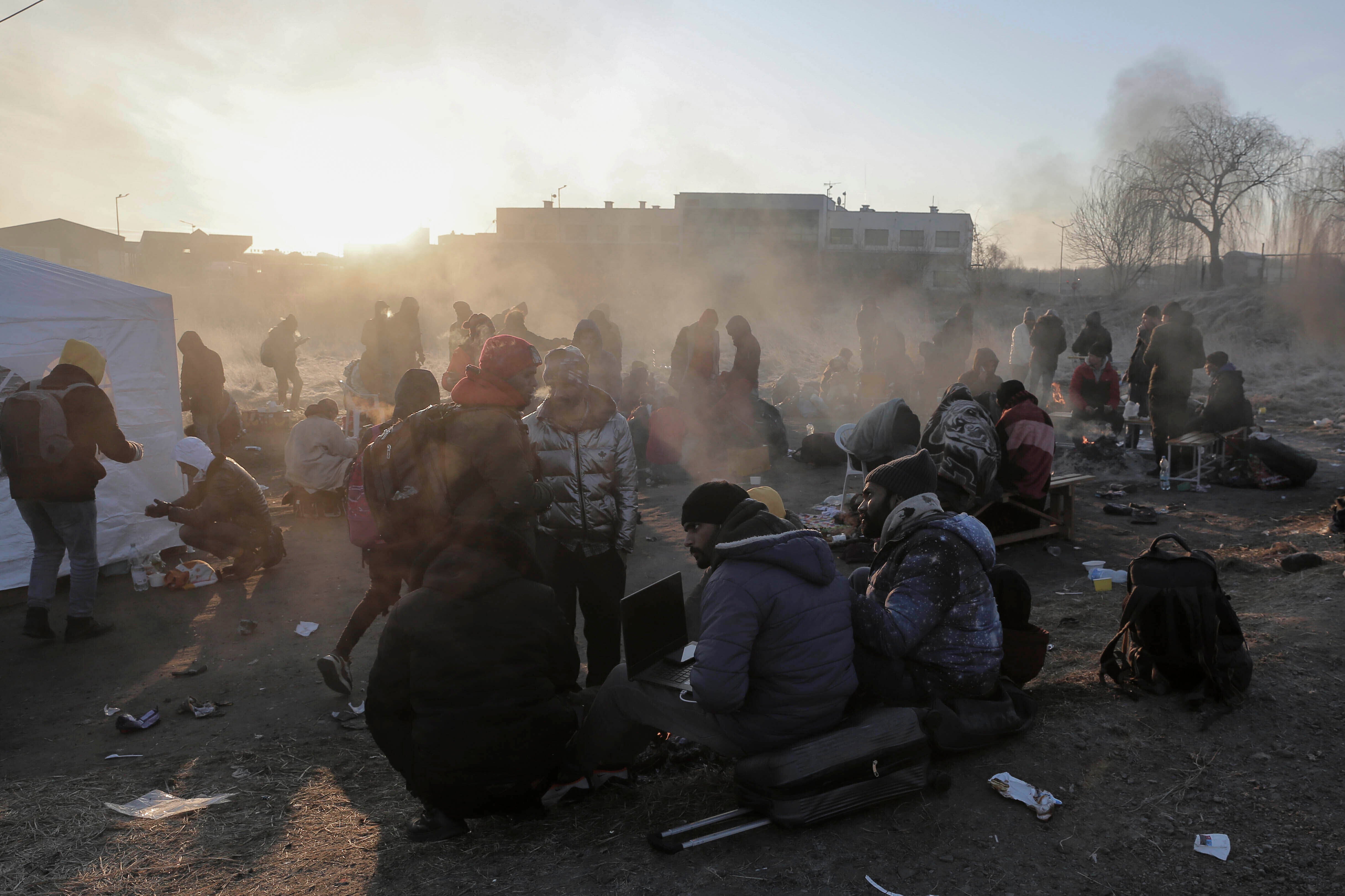 Refugees try to stay warm after fleeing the Russian invasion of Ukraine, at the Medyka border crossing in Poland, Tuesday, March 1, 2022. All day long, as trains and buses bring people fleeing Ukraine to the safety of Polish border towns, they carry not just Ukrainian fleeing a homeland under attack but large numbers of other citizens who had made Ukraine their home and whose fates too are now uncertain. (AP Photo/Visar Kryeziu)