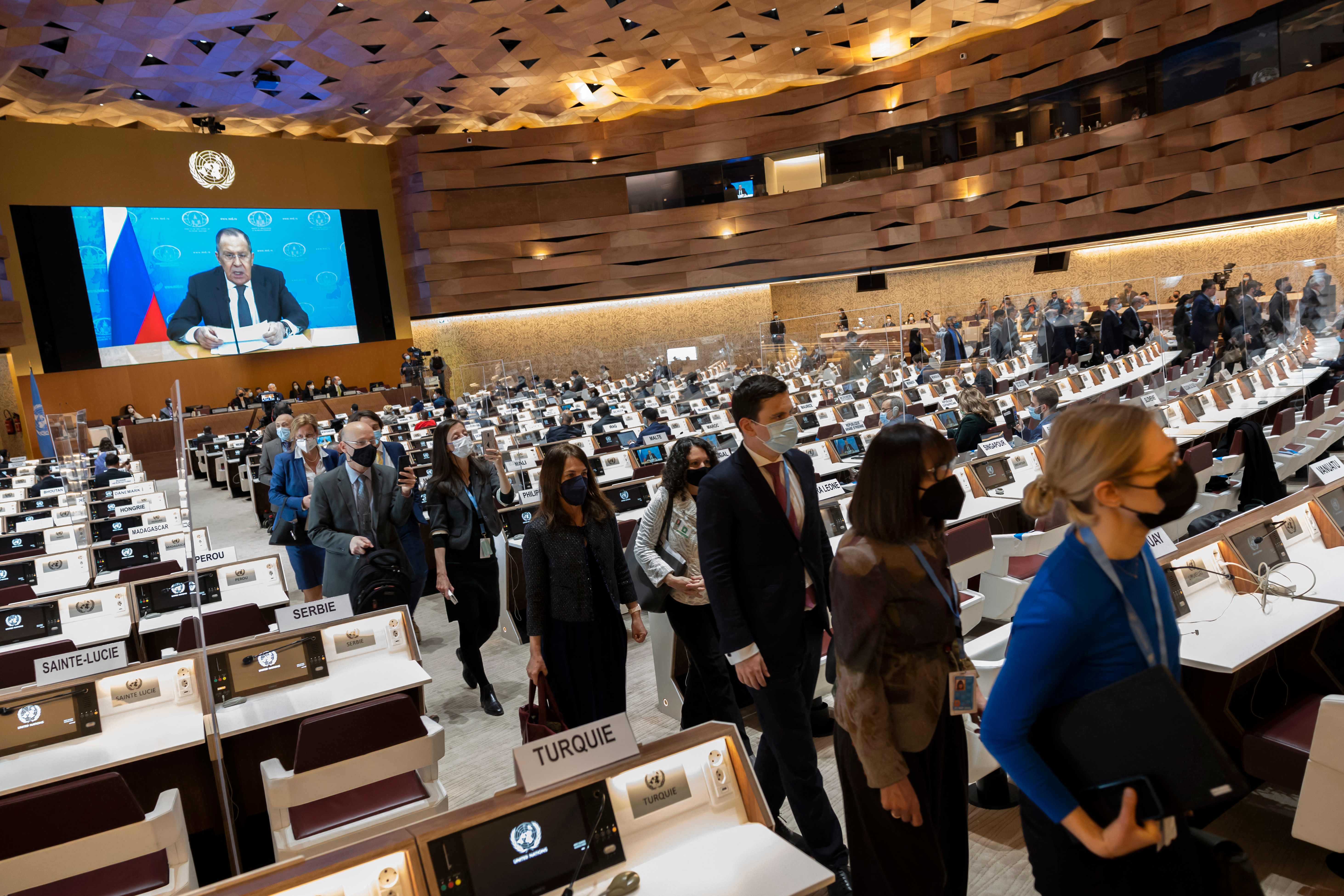 Ambassadors and diplomats leave while Russia’s foreign minister Sergei Lavrov (on screen) addresses with a pre-recorded message.