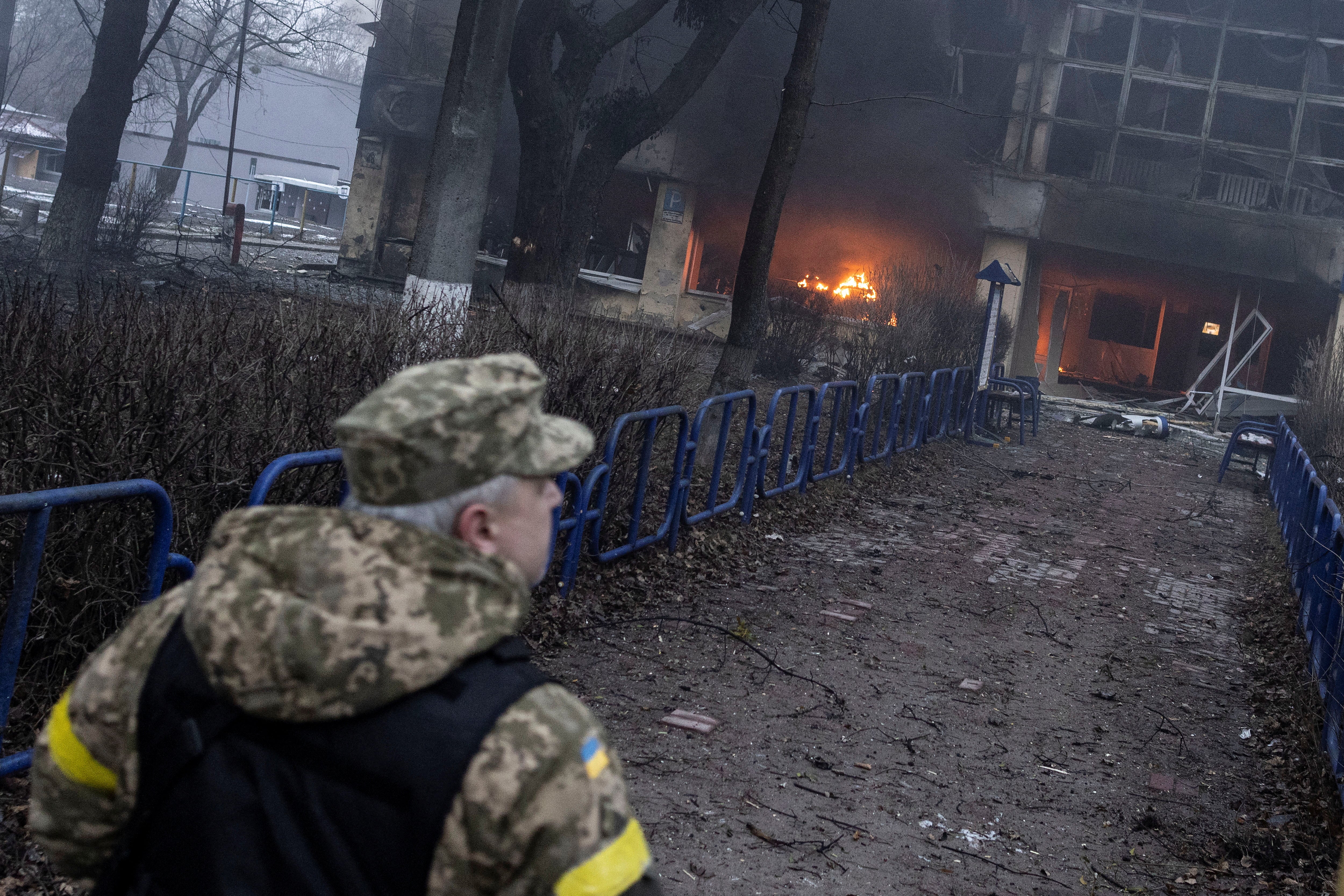 A member of the Ukraine military walks near a KyIv building after a blast on Tuesday