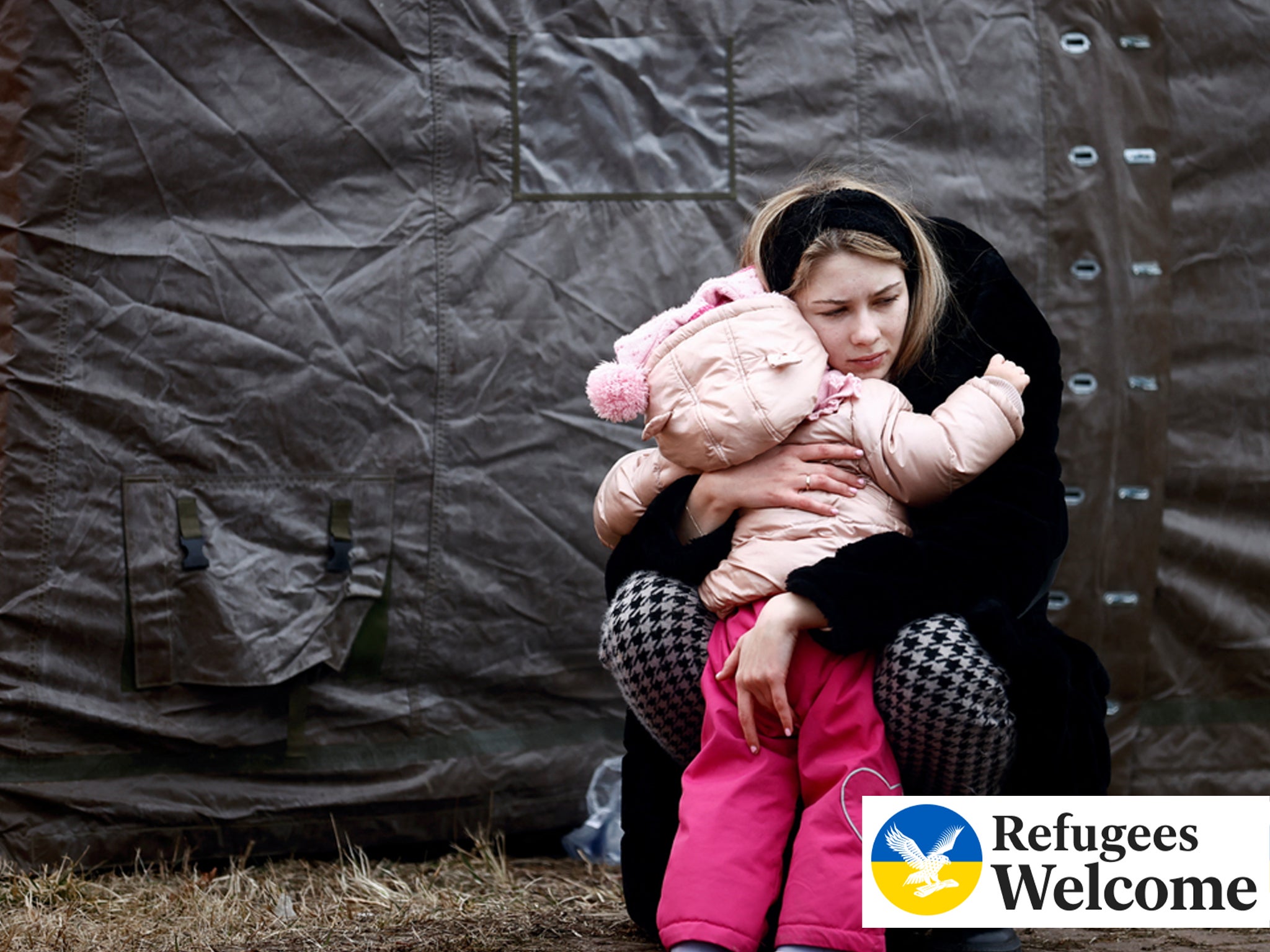 A woman fleeing Russian invasion of Ukraine hugs a child at a temporary camp in Przemysl, Poland, February 28, 2022.