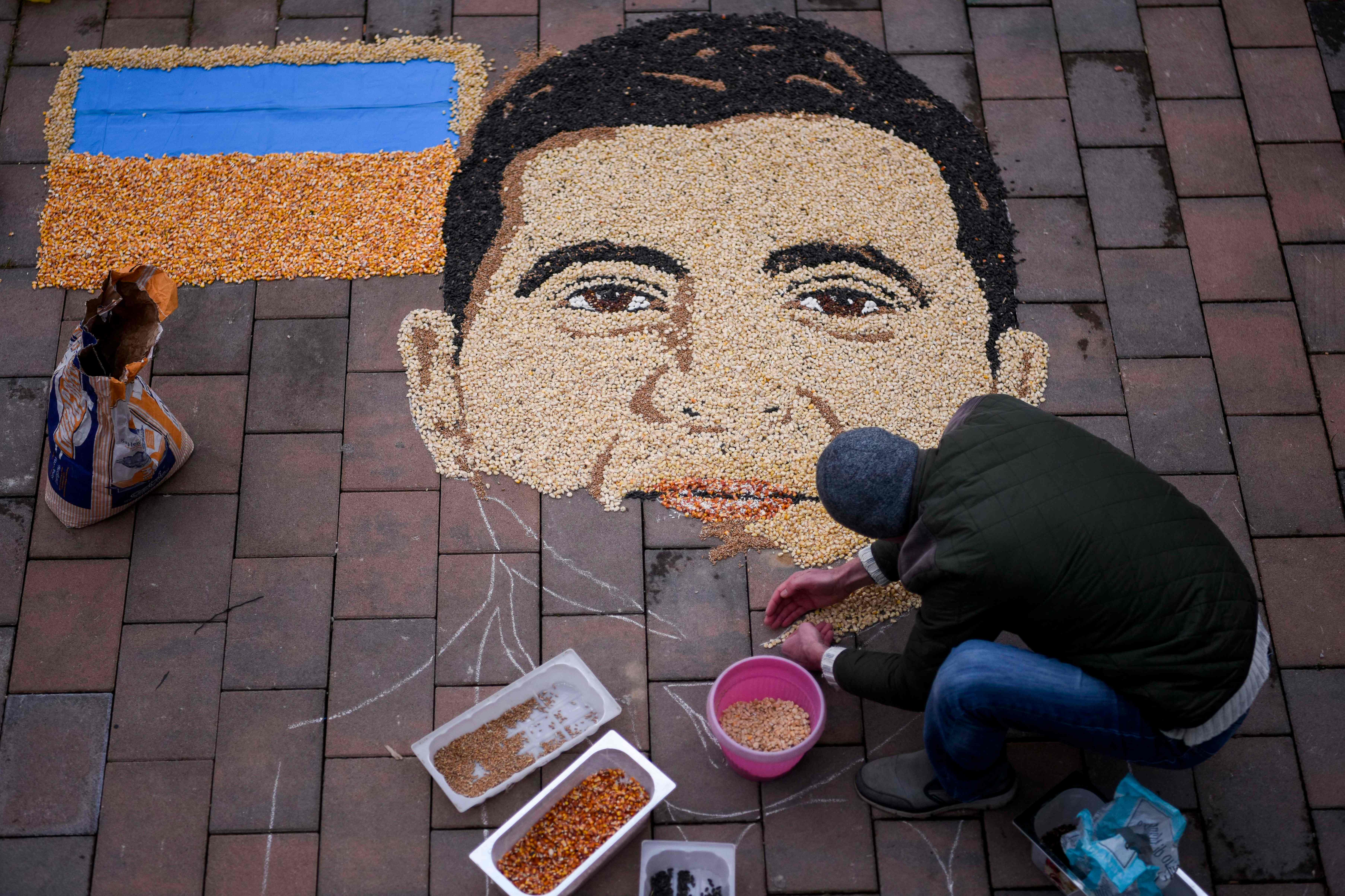 Artist Alkent Pozhegu works on the final touches of Volodymyr Zelensky's portrait made with grain and seed, in Gjakova, southwestern Kosovo