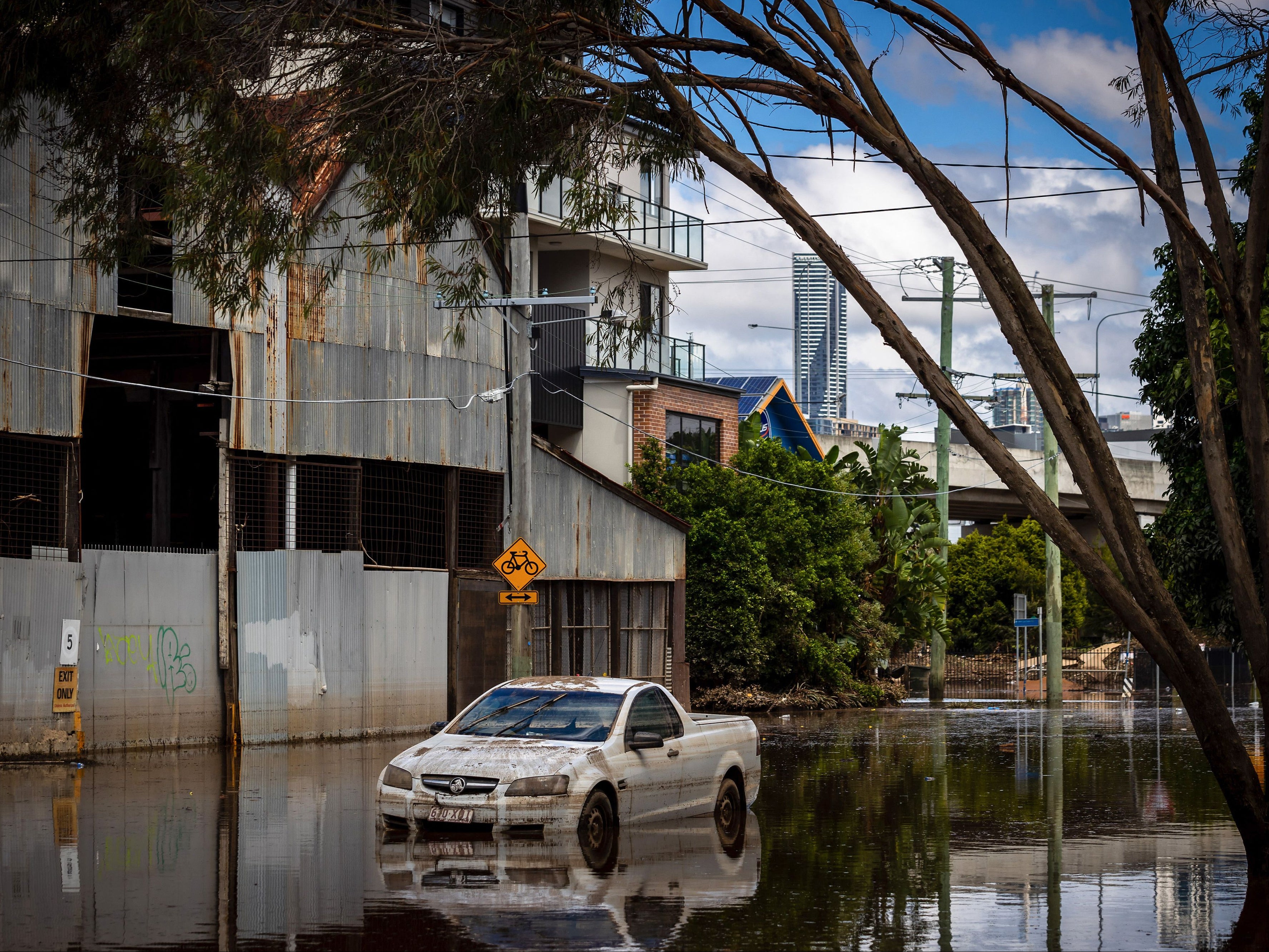 An abandoned car is seen in floodwaters in the suburb of Newmarket in Brisbane