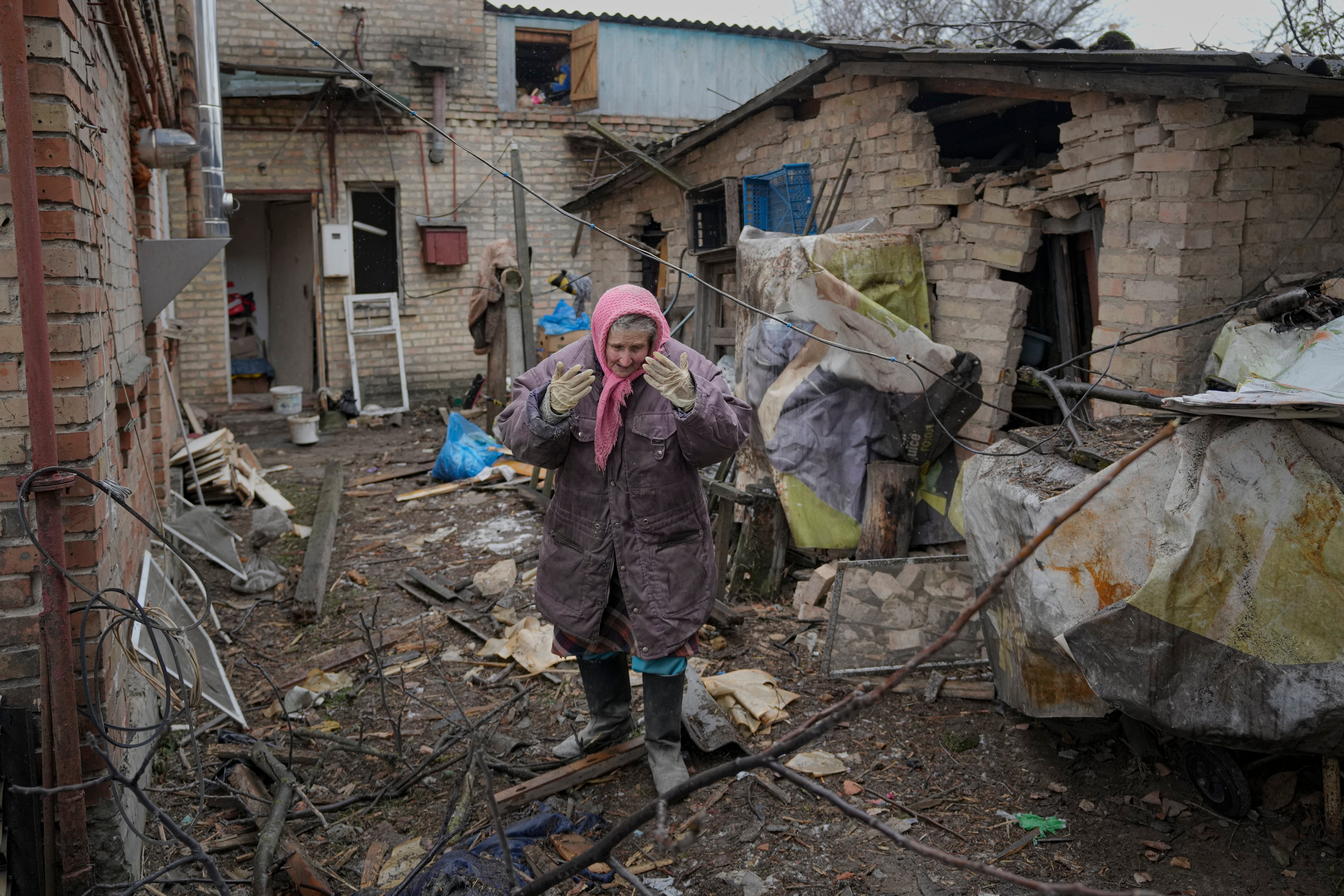 A lady is overwhelmed by emotion in the backyard of a house damaged by a Russian airstrike, according to locals, in Gorenka, outside the capital Kyiv, Ukraine