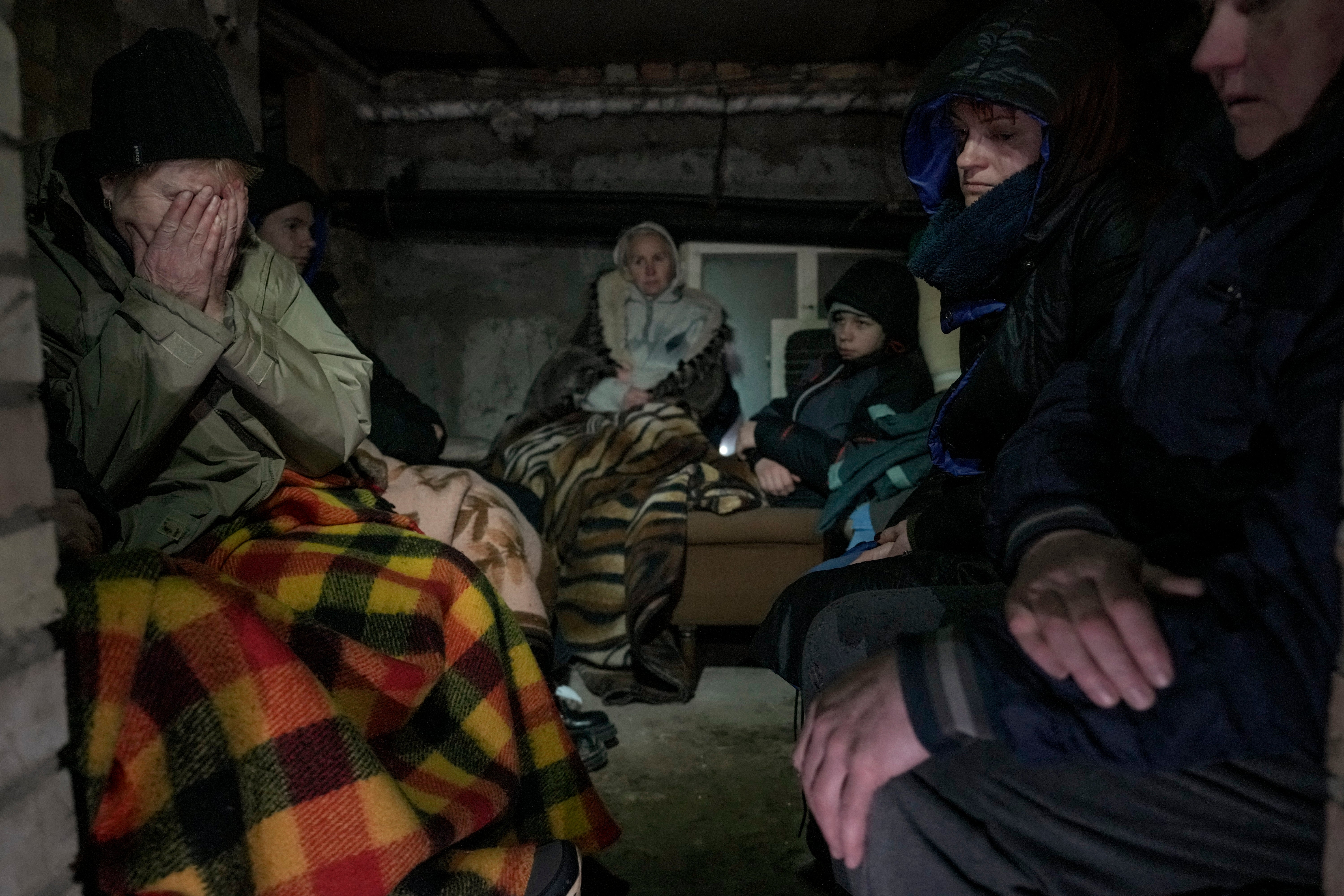 A woman cries in the cellar of a house crowded with people sheltering from Russian airstrikes, outside Kyiv