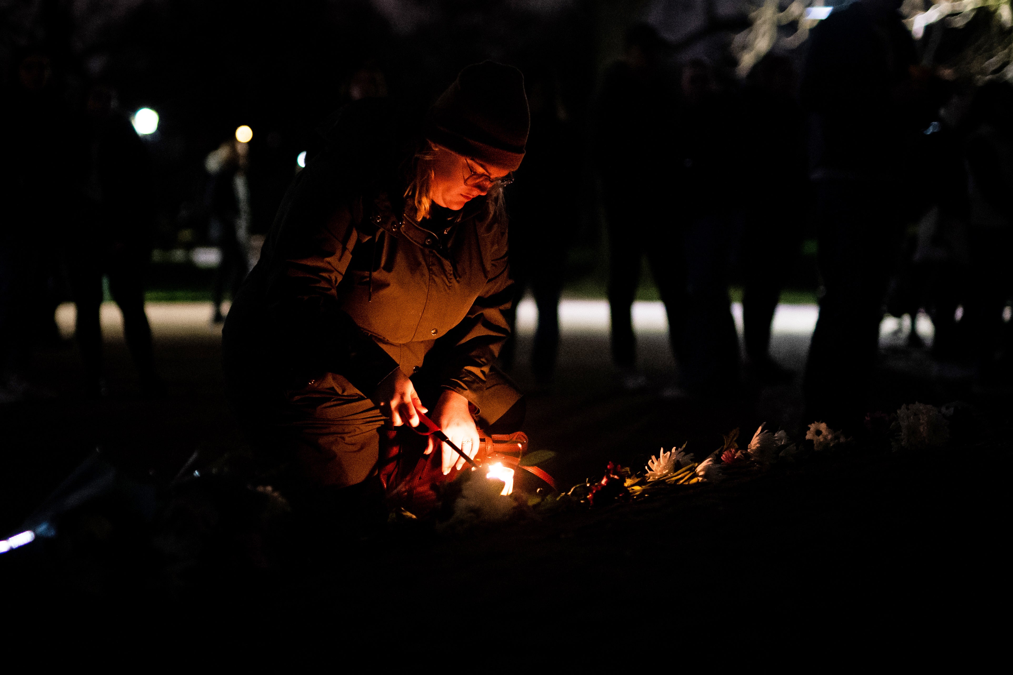 A person lights a candle at Clapham Common in south London, following a march to mark the first anniversary of the murder of Sarah Everard (Aaron Chown/PA)