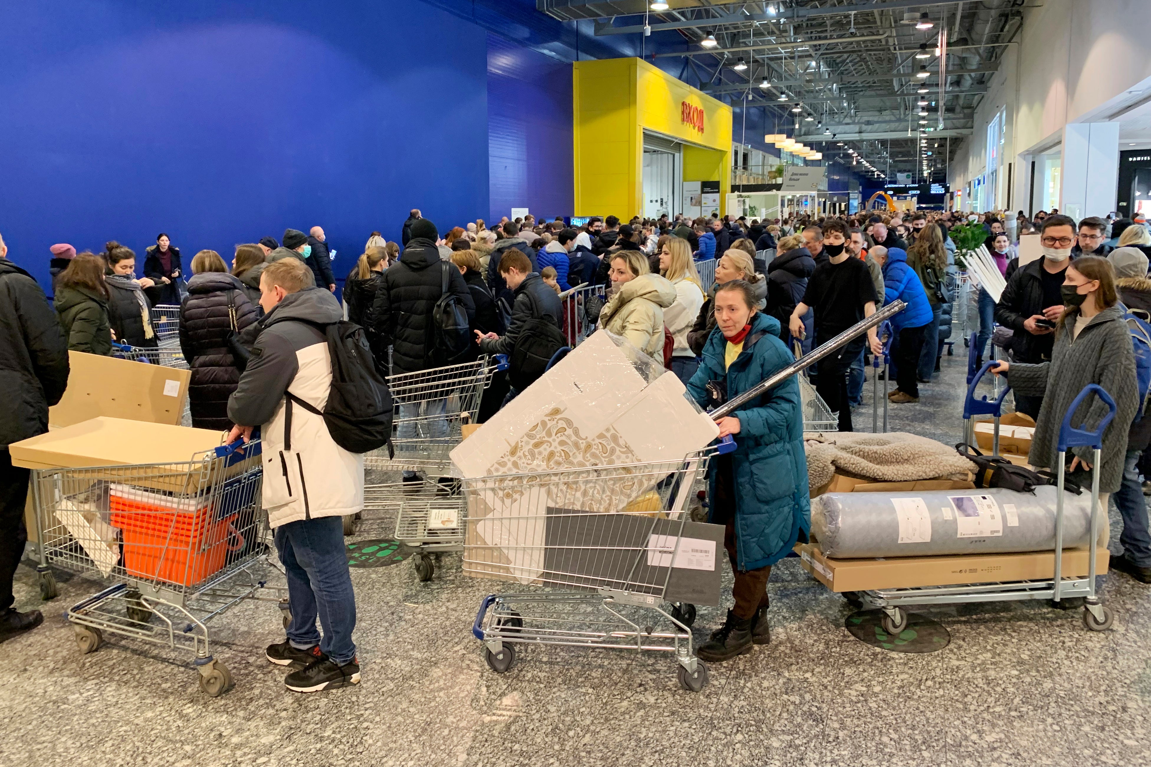 People wait in a line to pay for her purchases at the Ikea store on the outskirts of Moscow.