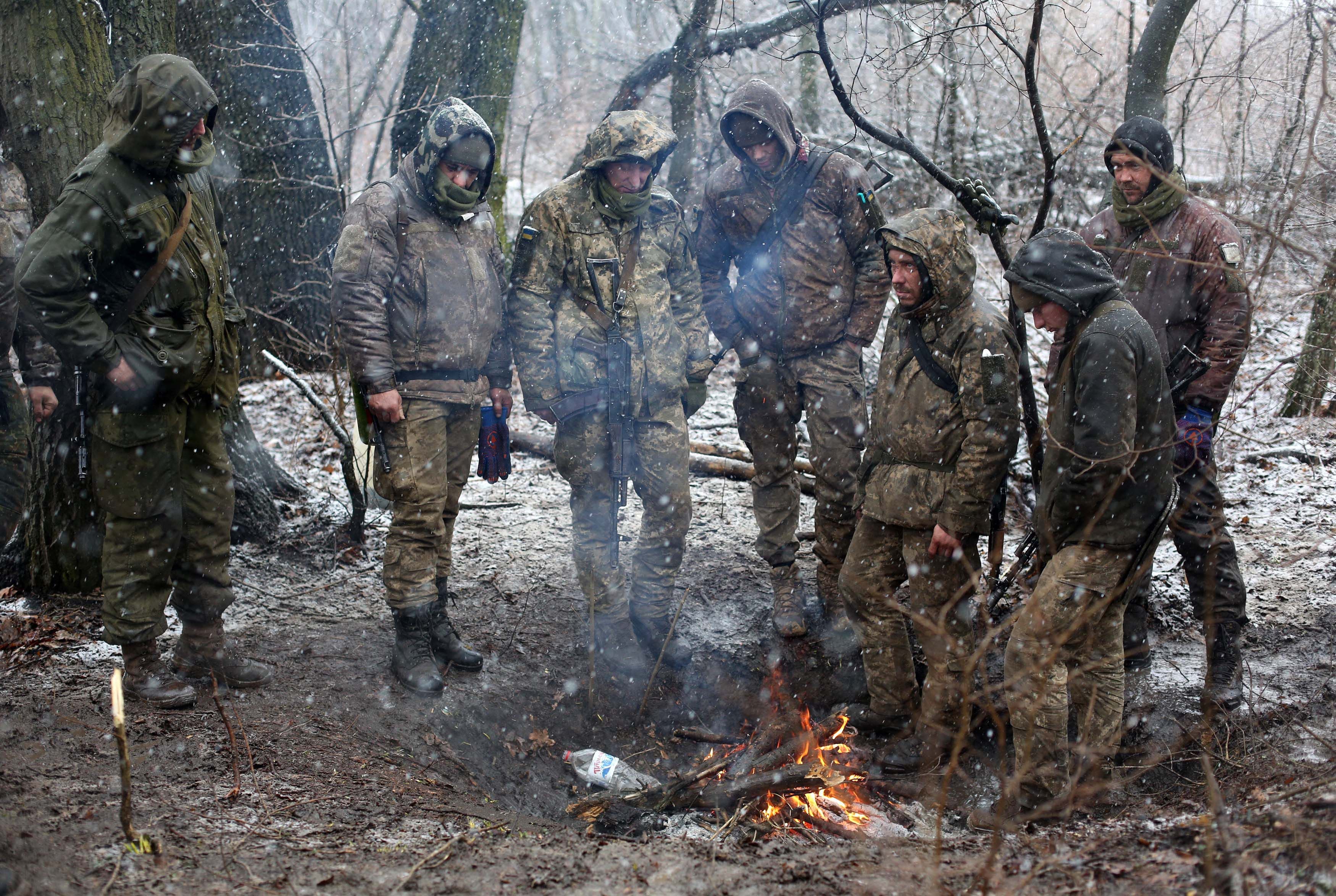 Ukrainian Military Forces servicemen in Luhansk stand by a fire to keep warm