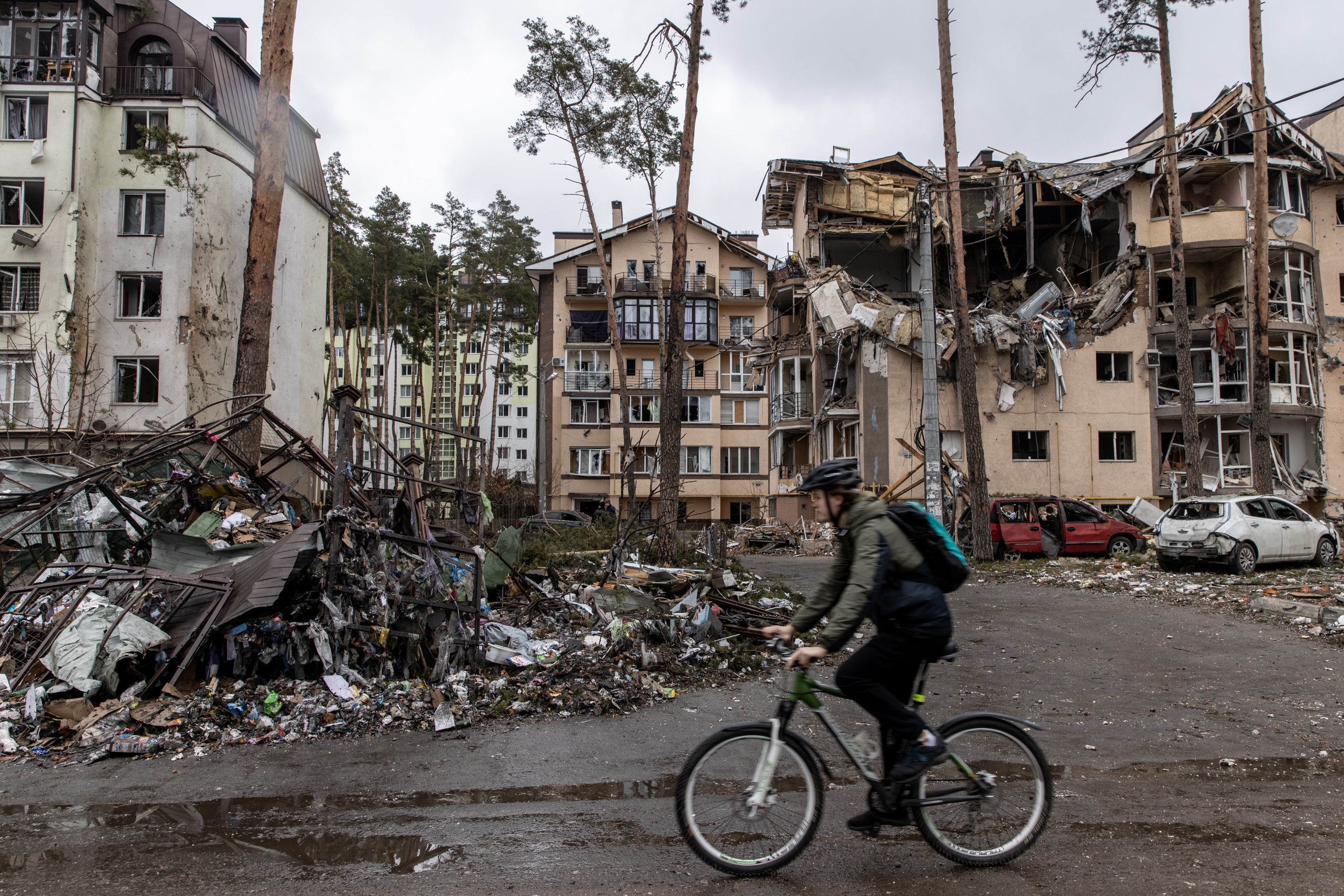 A man rides his bike past buildings destroyed by Russian shelling in Irpin, Ukraine.