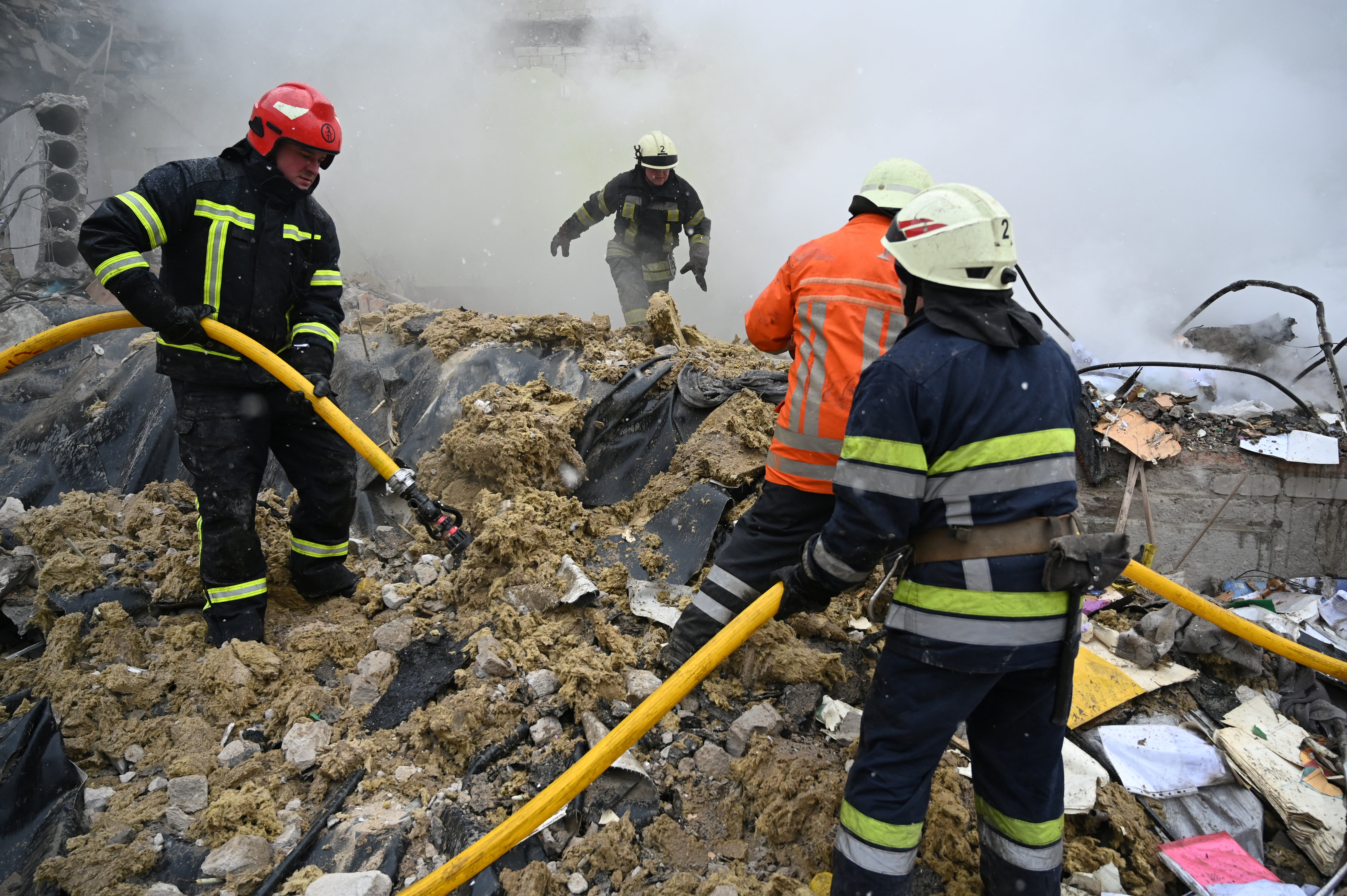 Rescuers work amidst the debris of the school building