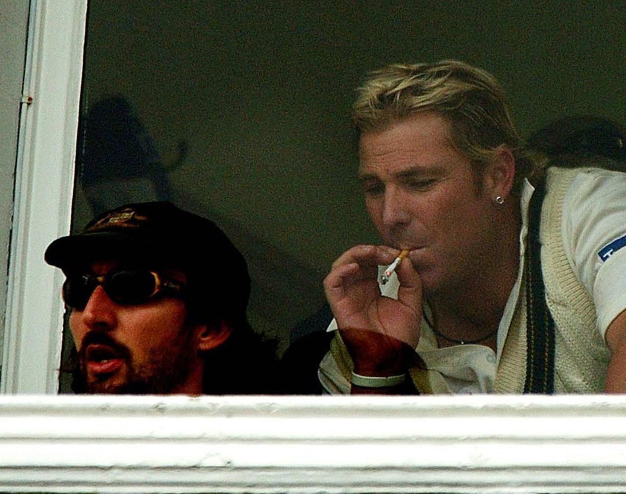 Warne puffs on a cigarette in the dressing room during a rain delay against England during an Ashes Test match at Trent Bridge in August 2005 (Rui Vieira/PA)