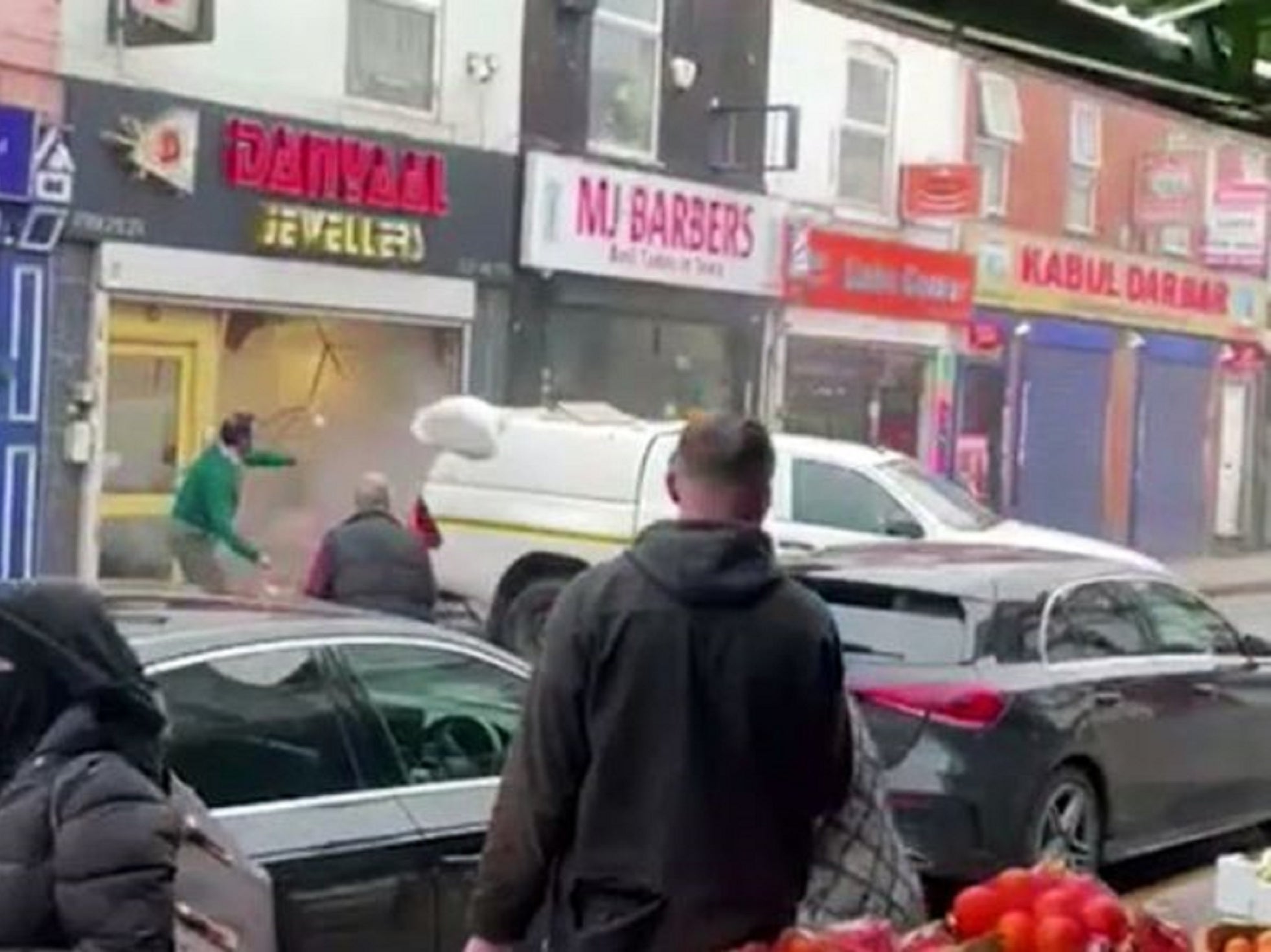 A man in a green jumper attempted to intervene by throwing rubbish bags at a highways maintenance vehicle as masked ram raiders smashed their way into a jewellers in Birmingham