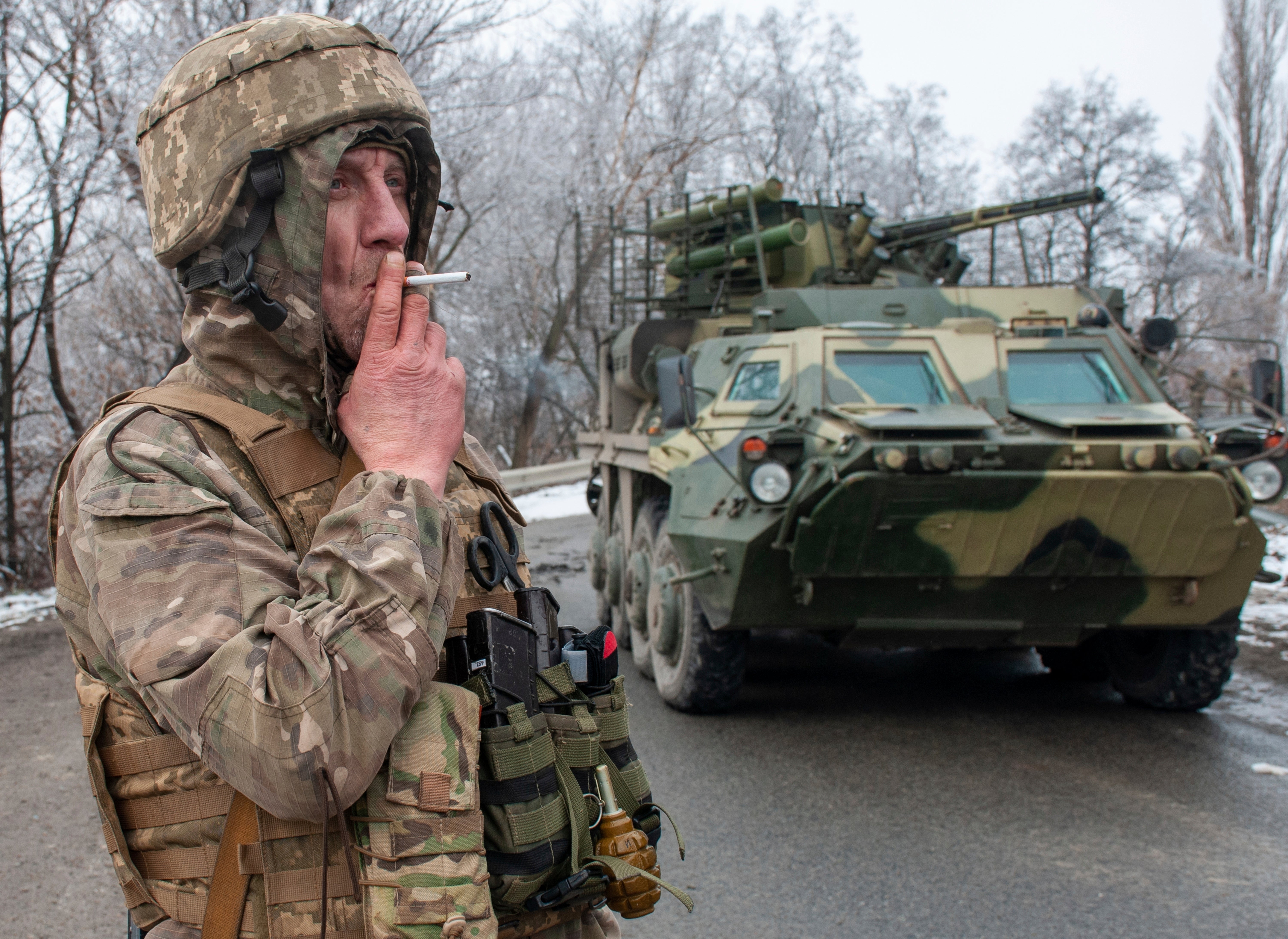 A Ukrainian soldier smokes a cigarette on his position at an armoured vehicle outside Kharkiv, Ukraine, 26 February 2022