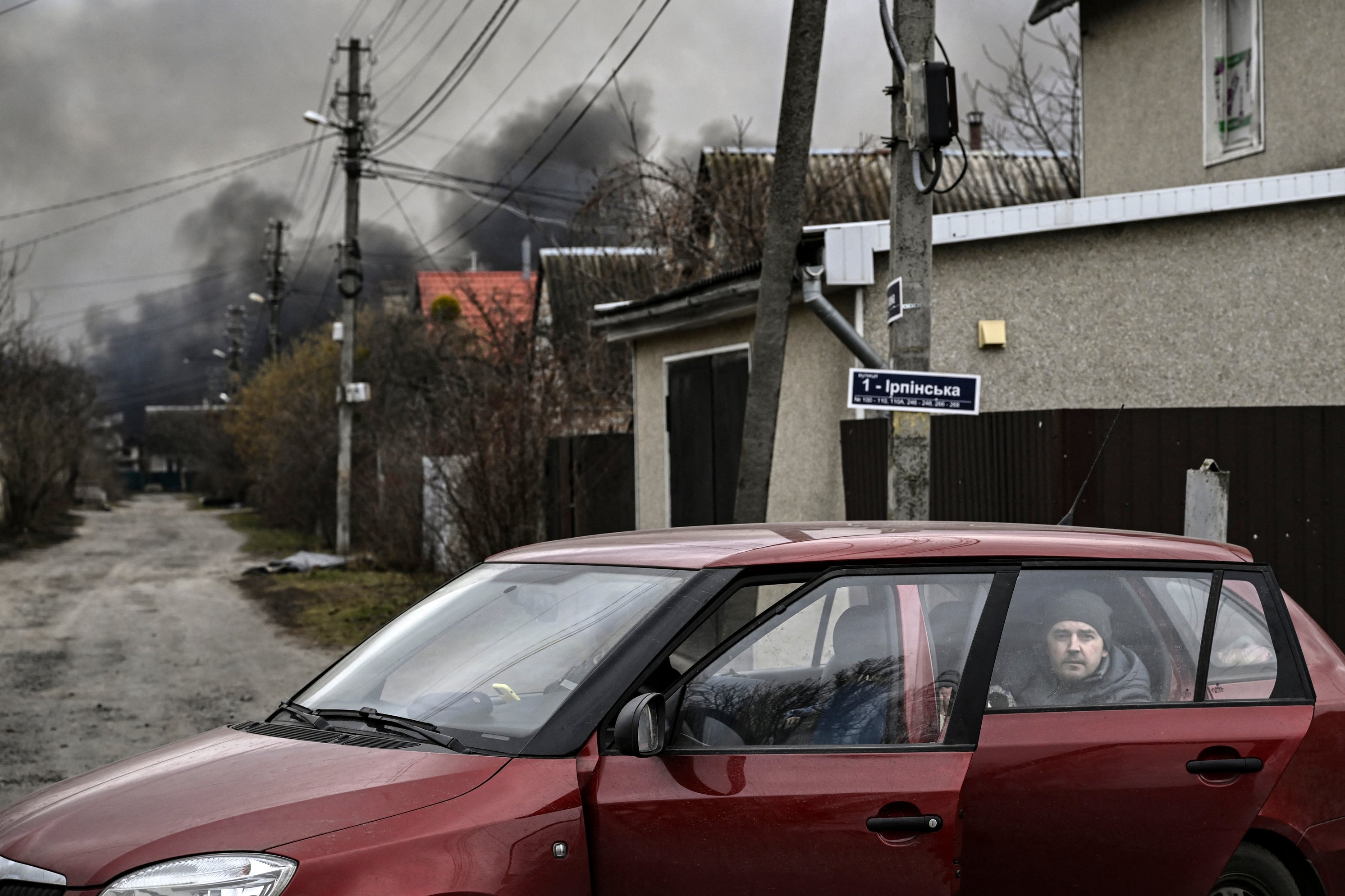 A man looks on as he sits in the back of a car in the town of Stoyanka, west of Kyiv