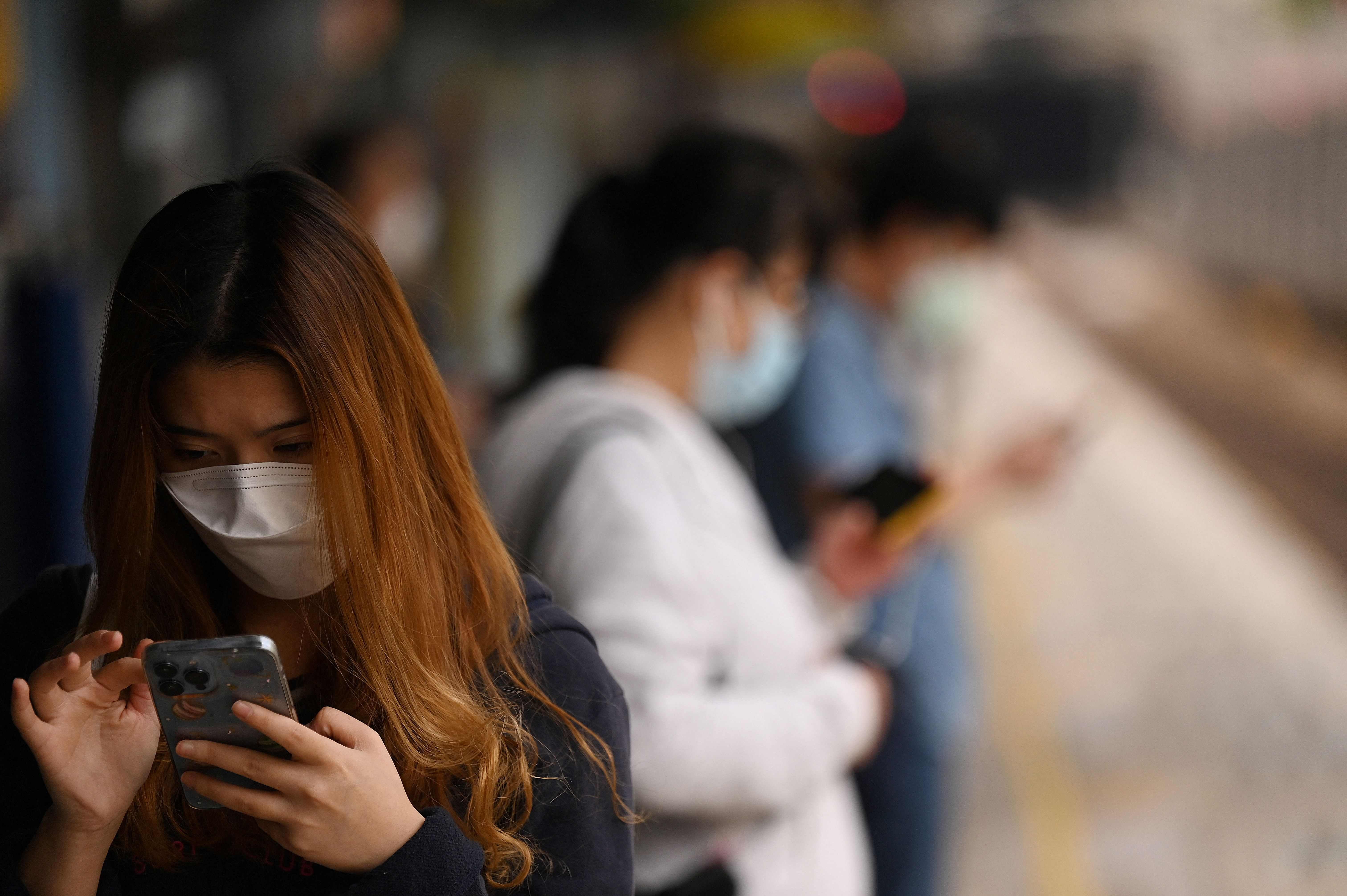 People wear masks on a train platform in Hong Kong