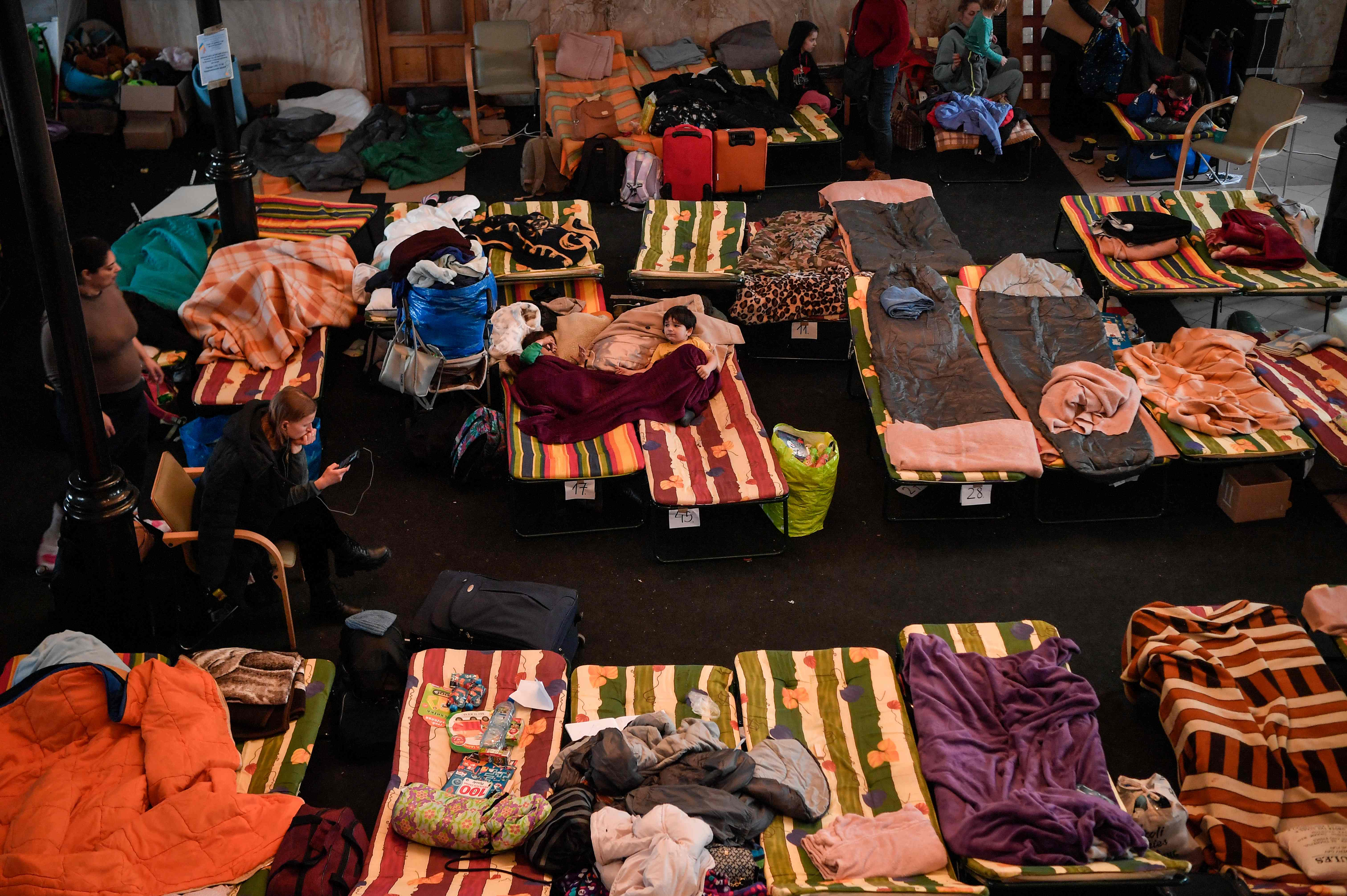 Refugees from Ukraine rest at a temporary shelter in Krakow’s main railway station on 6 March, as they wait to be relocated to other temporary accommodation in Poland or abroad