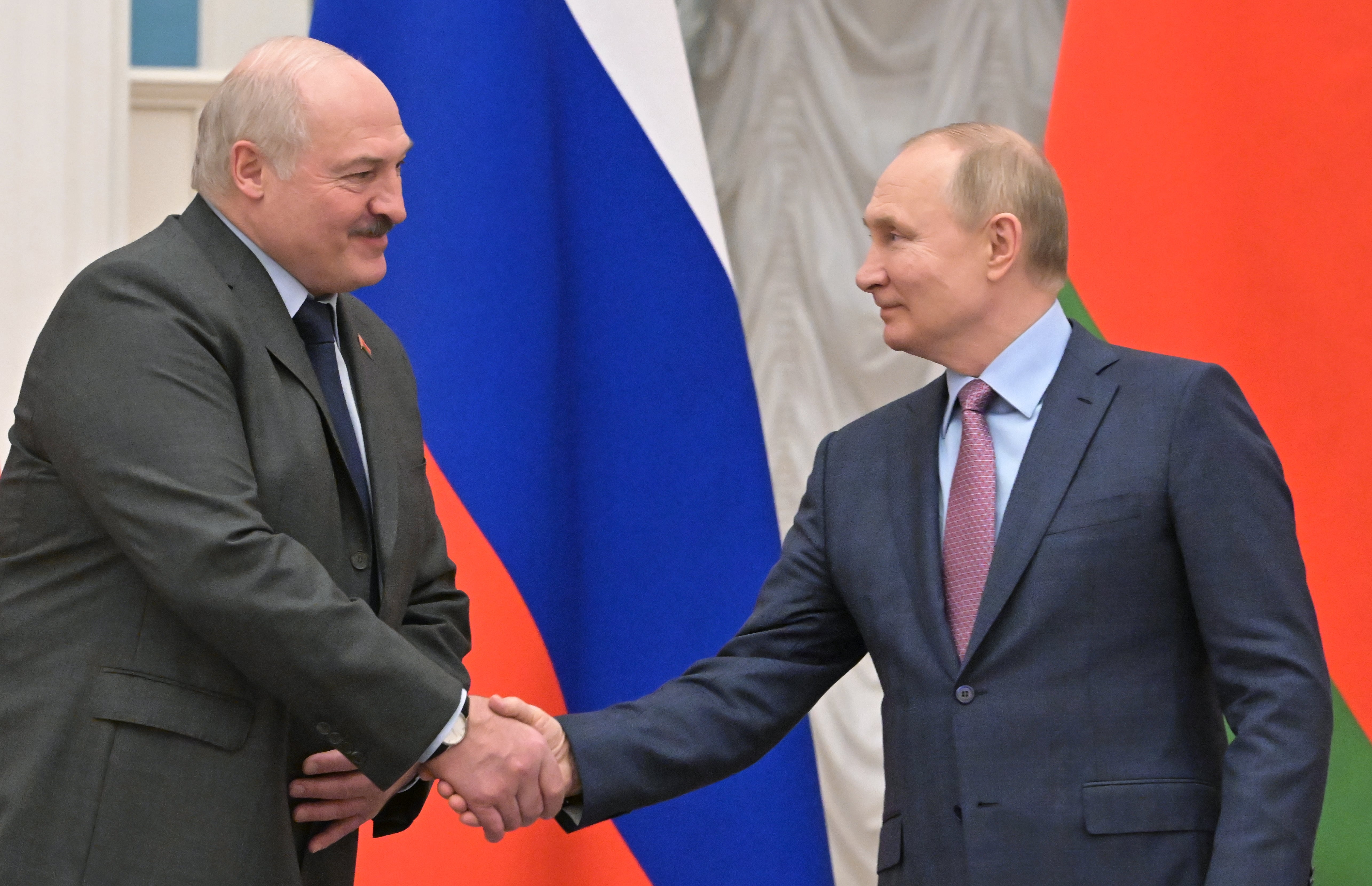 Alexander Lukashenko (L) and Vladimir Putin shake hands during a joint press conference following their talks at the Kremlin in February