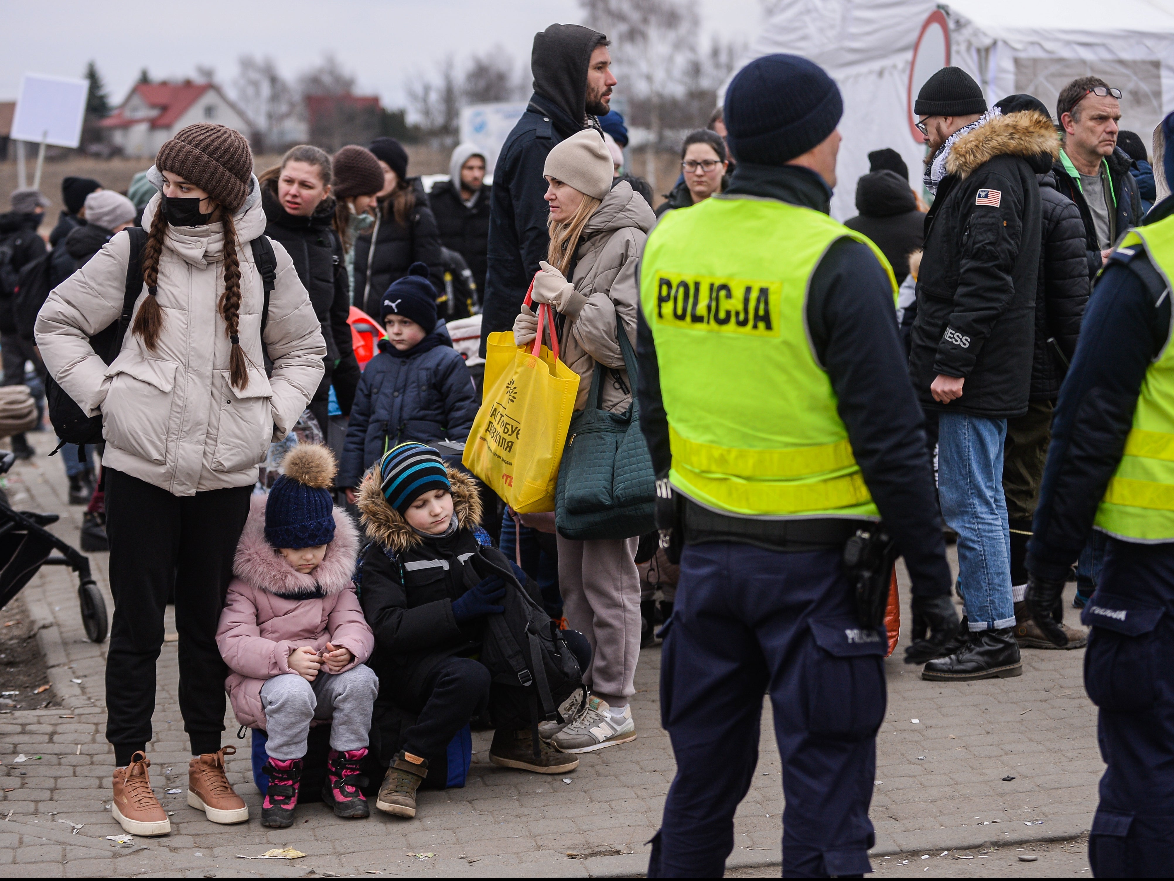 People who fled the war in Ukraine wait to board a bus in Medyka, Poland, after crossing the Polish Ukrainian border