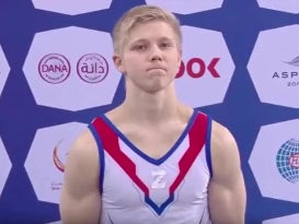 Russian gymnast Ivan Kuliak stands in a shirt that shows letter Z to receive his bronze medal