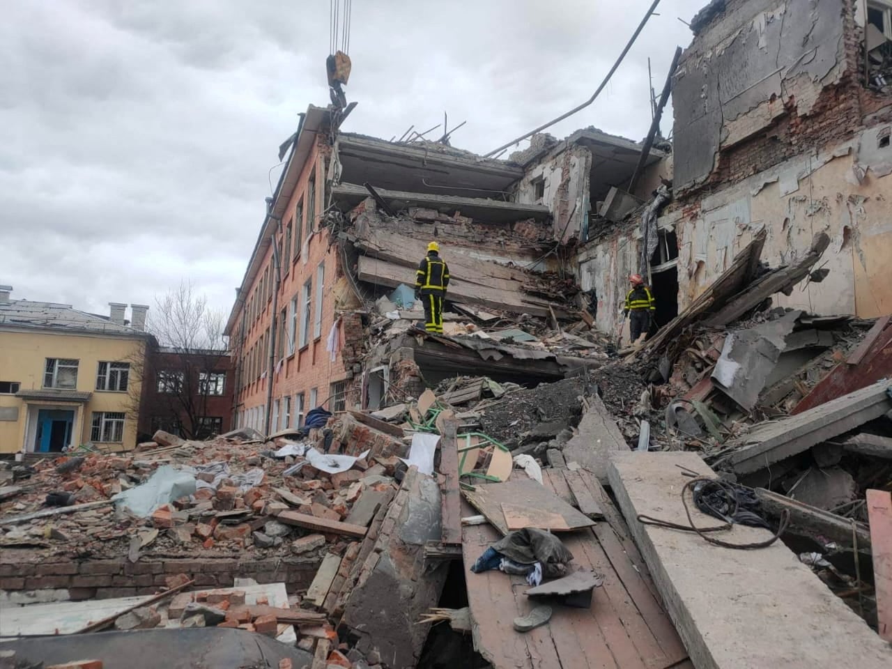 Rescuers remove debris from a school building damaged by shelling in Chernihiv, Ukraine.