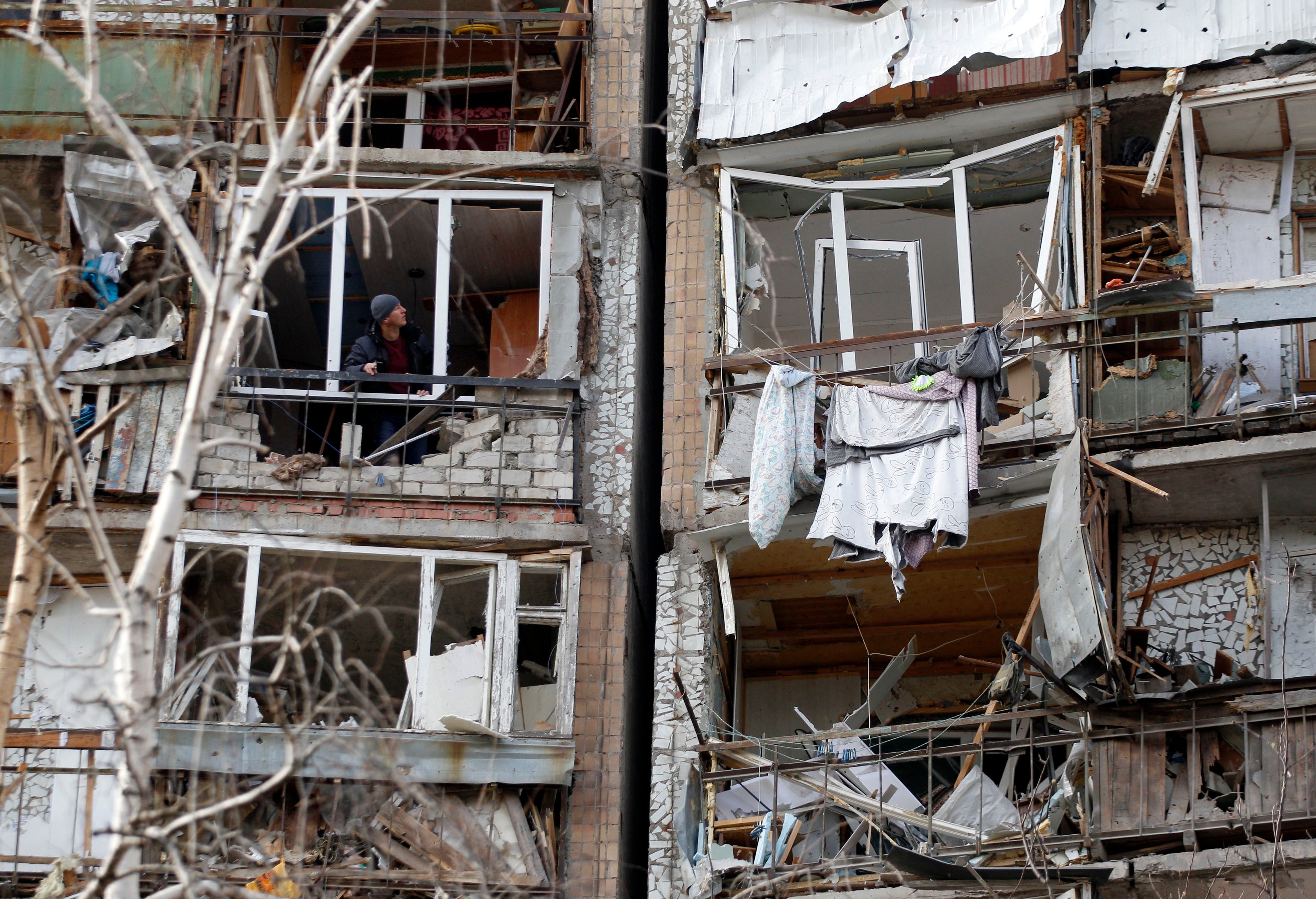 A resident looks out of the destroyed front of a room, which was badly damaged as a result of Russian missile explosion in Kramatorsk.